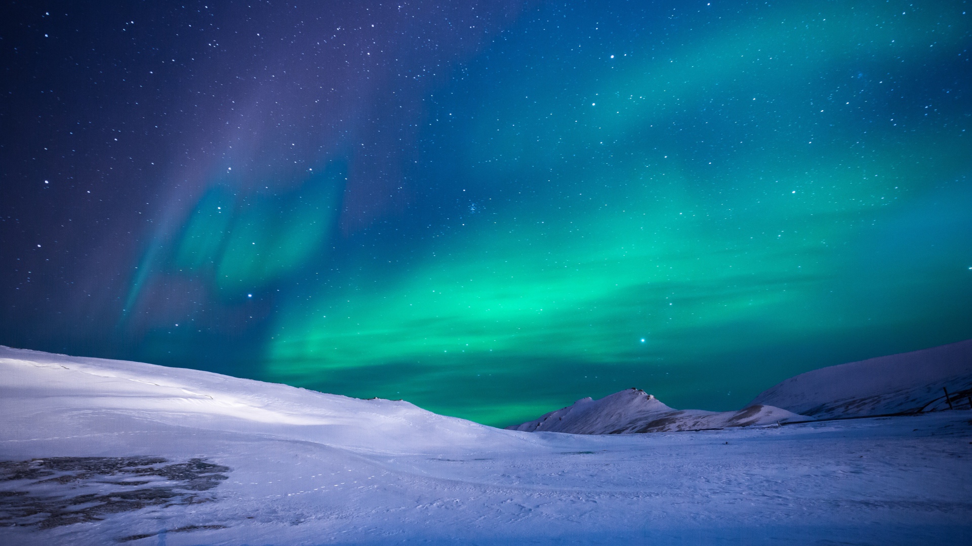 Aurora over snow-capped hills