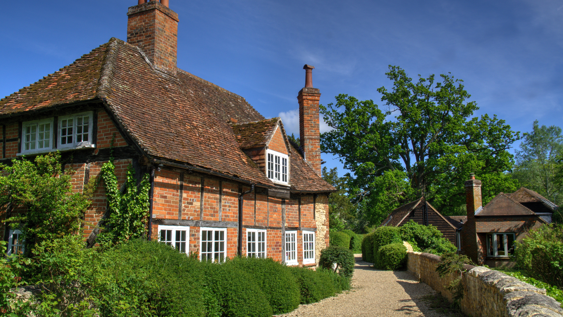Кирпичный старый дом под голубым небом, Англия 