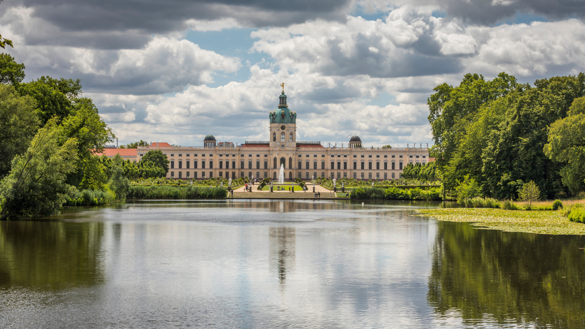 Красивый вид на замок Шарлоттенбург у озера под белыми облаками