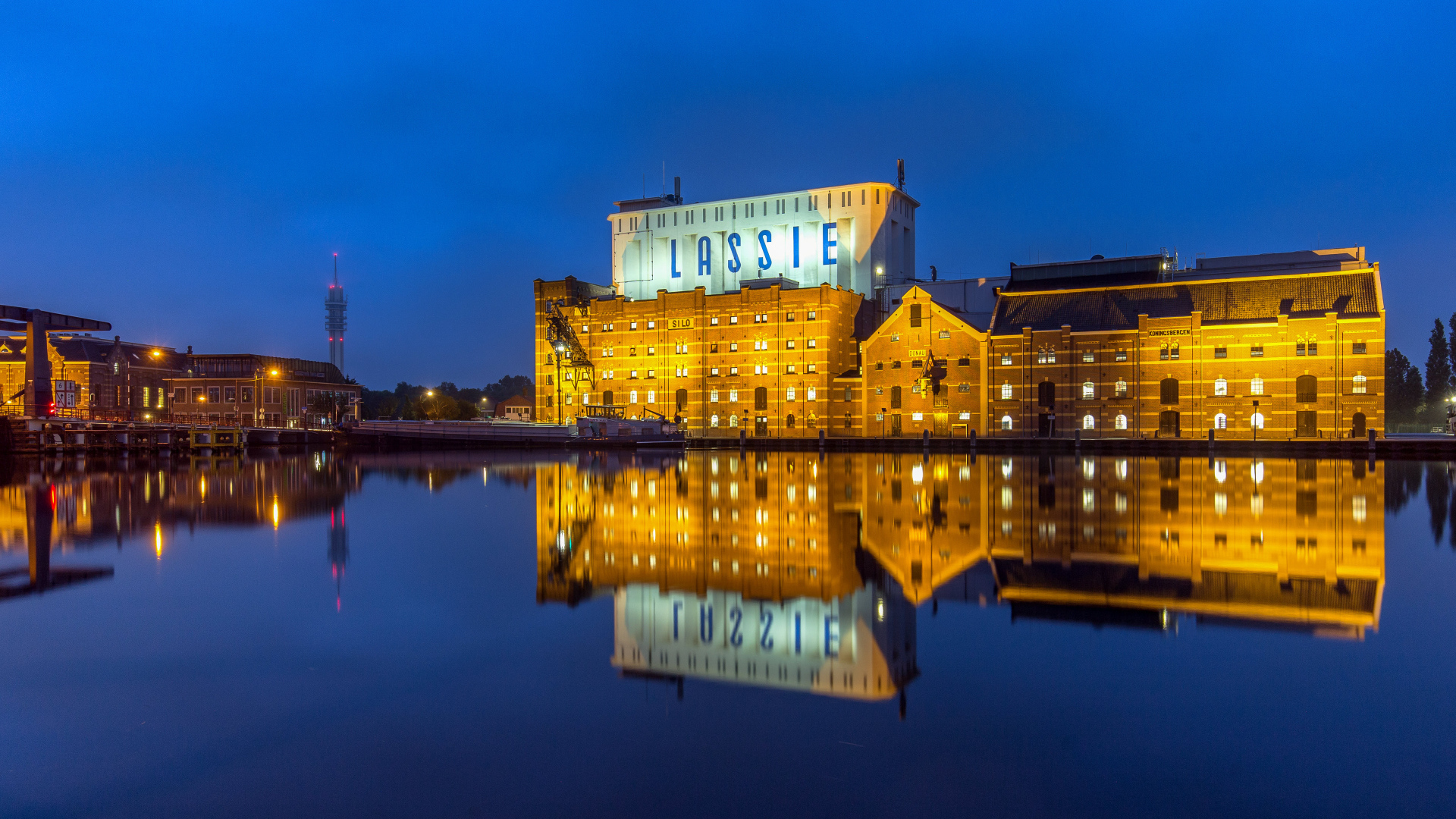 Здание завода у воды ночью, Нидерланды