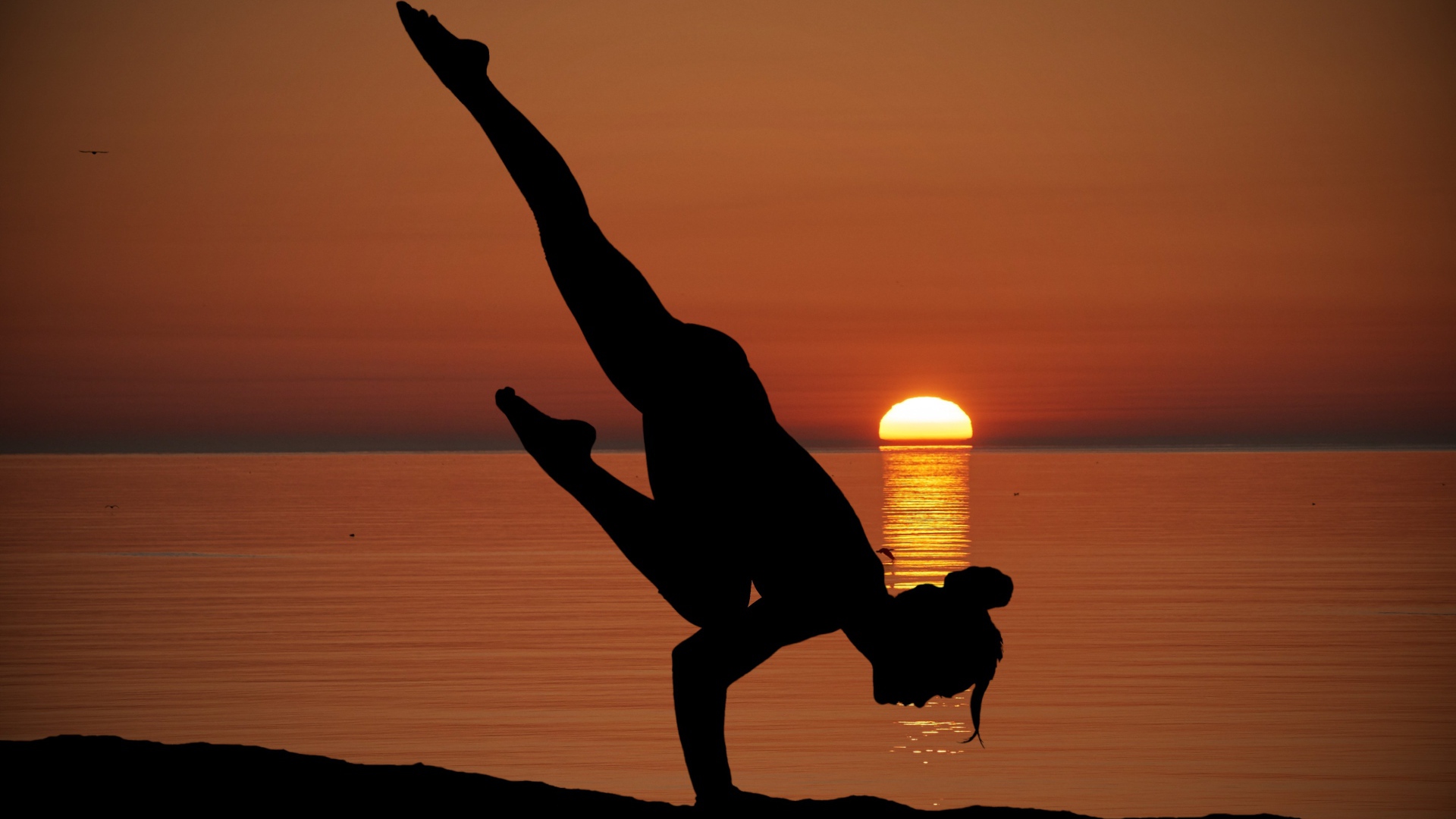 Девушка занимается йогой на закате солнца