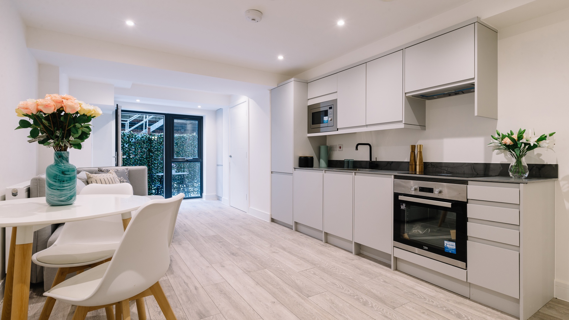 Большая просторная белая гостиная с букетом роз