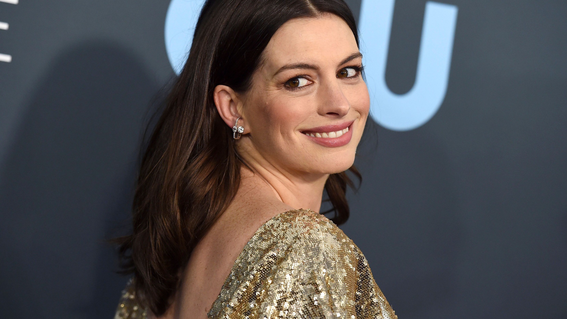 Smiling actress Anne Hathaway in a bright dress