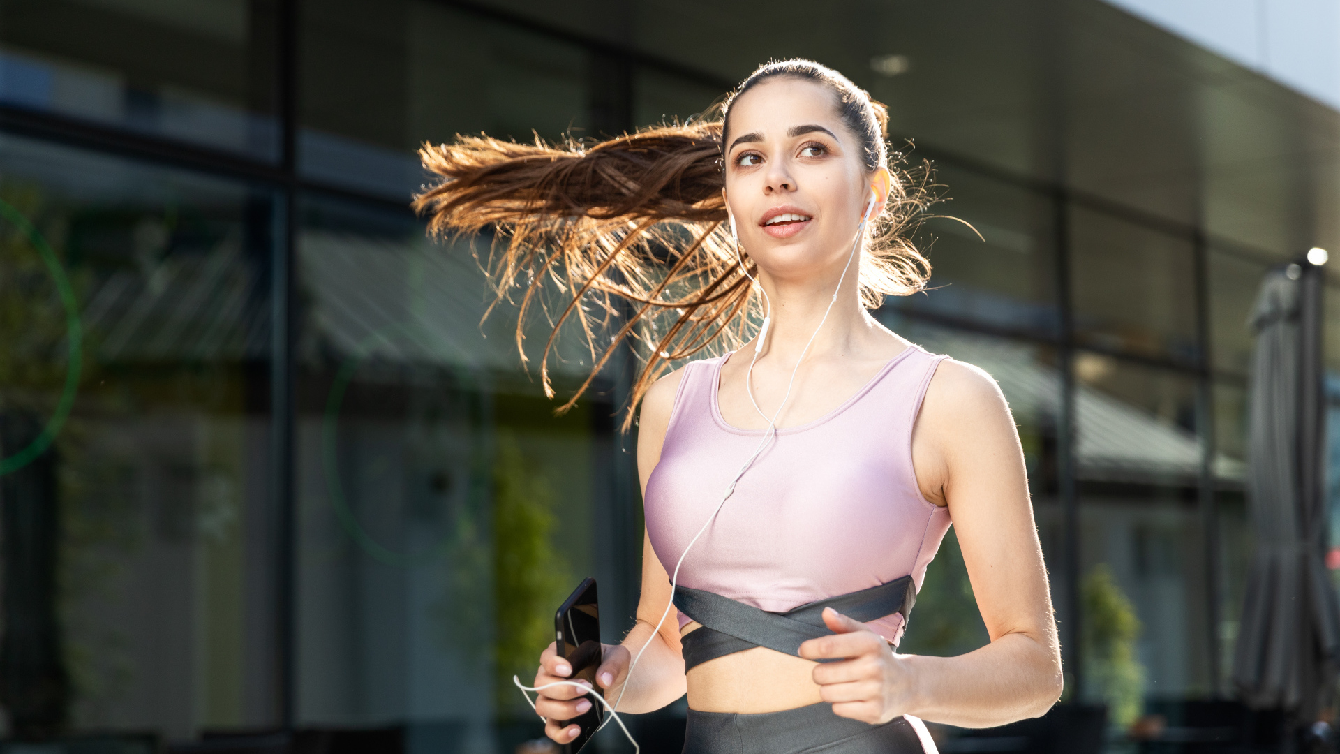 Спортивная девушка занимается бегом на улице