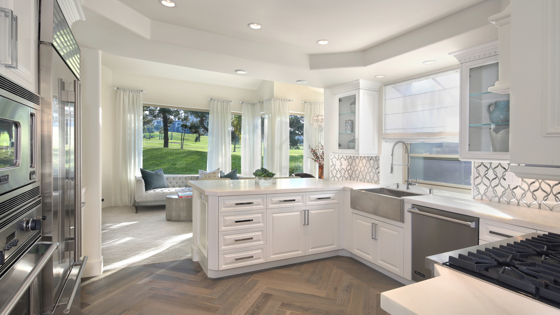 Белый кухонный гарнитур в комнате с большим окном