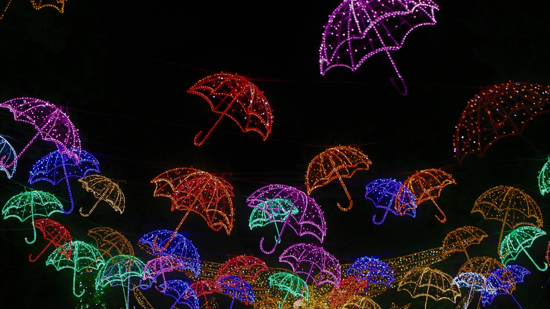 Разноцветные неоновые зонтики на черном фоне