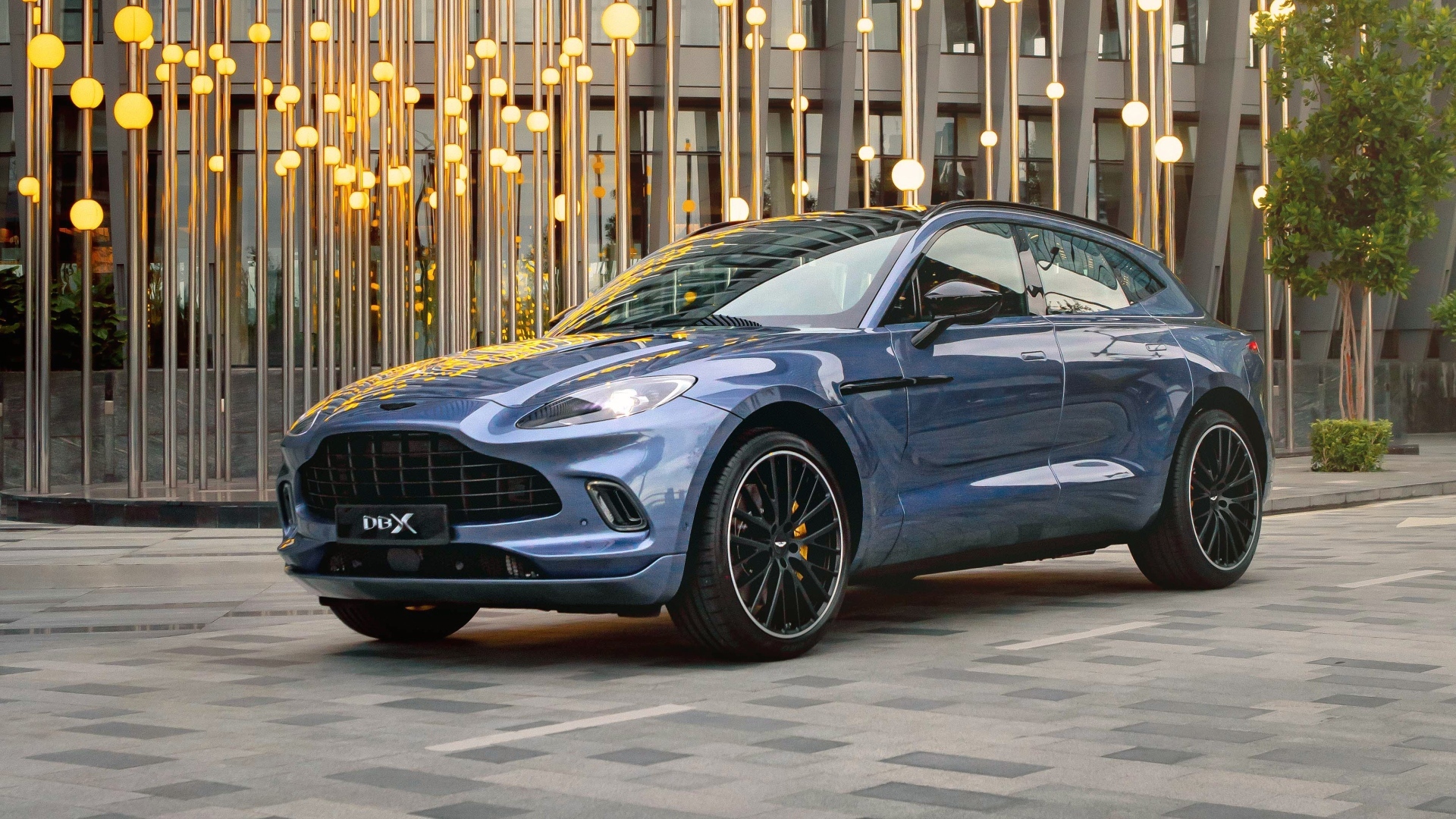 Автомобиль Aston Martin DBX у здания