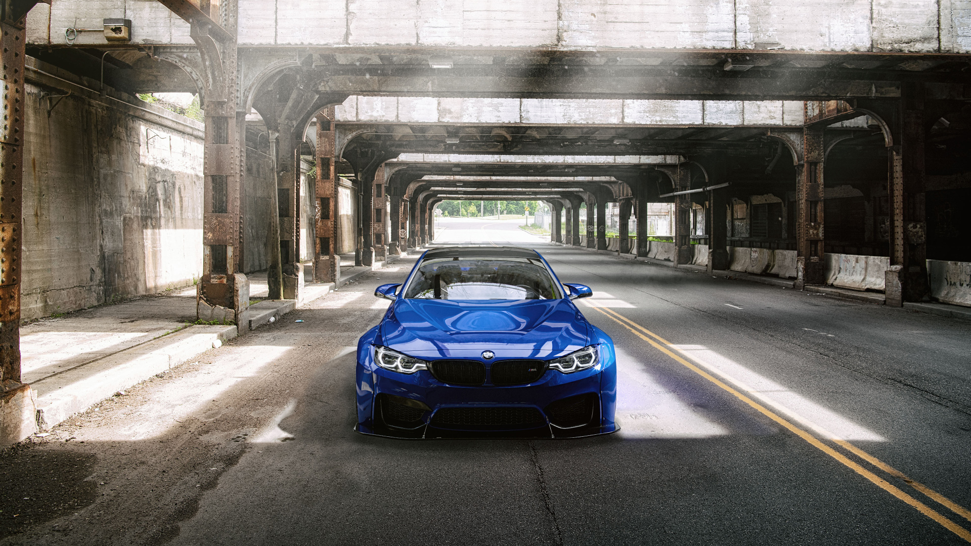 Синий автомобиль BMW M4 под мостом