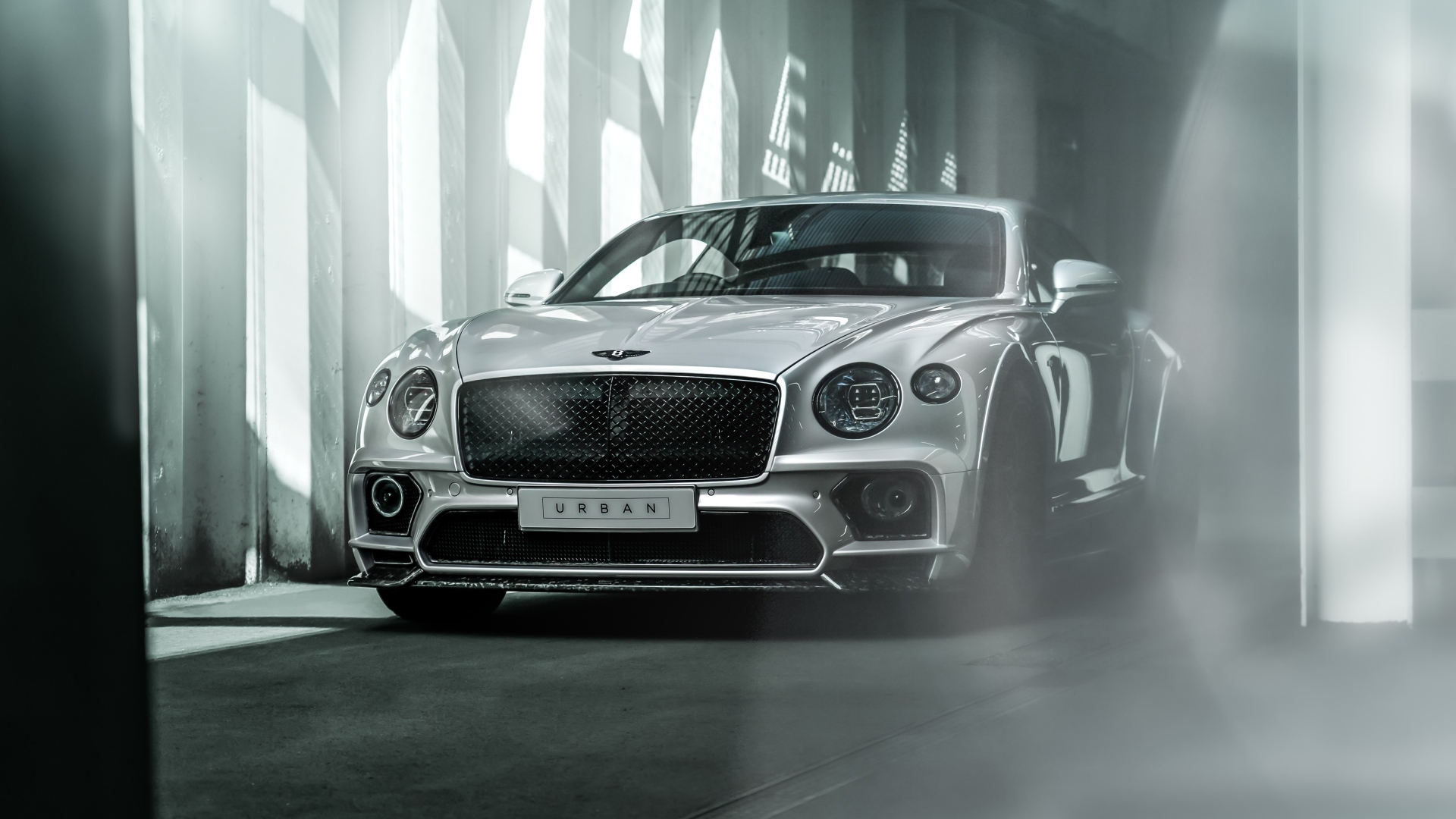 Серебристый автомобиль Bentley Continental GT в здании