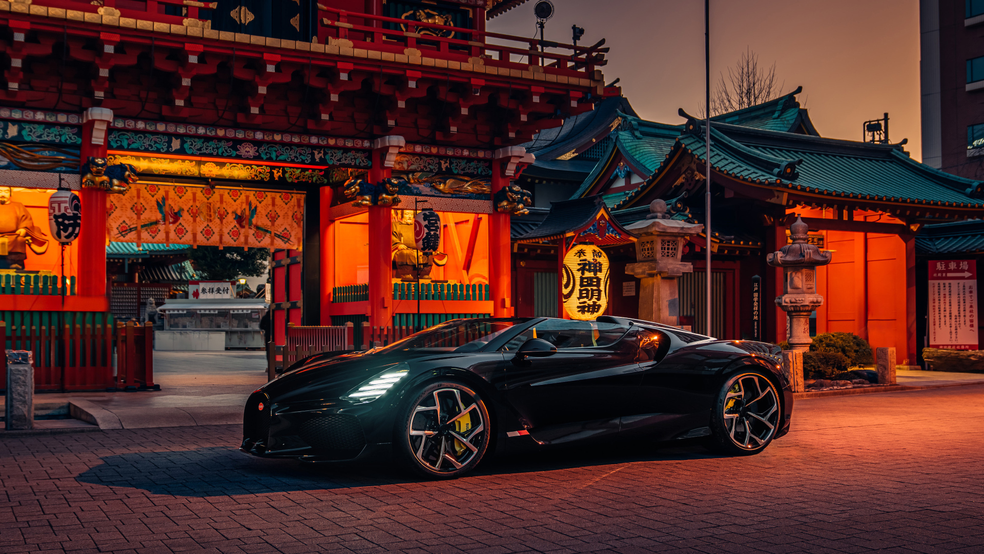 Черный спортивный автомобиль Bugatti W16 Mistral  у здания