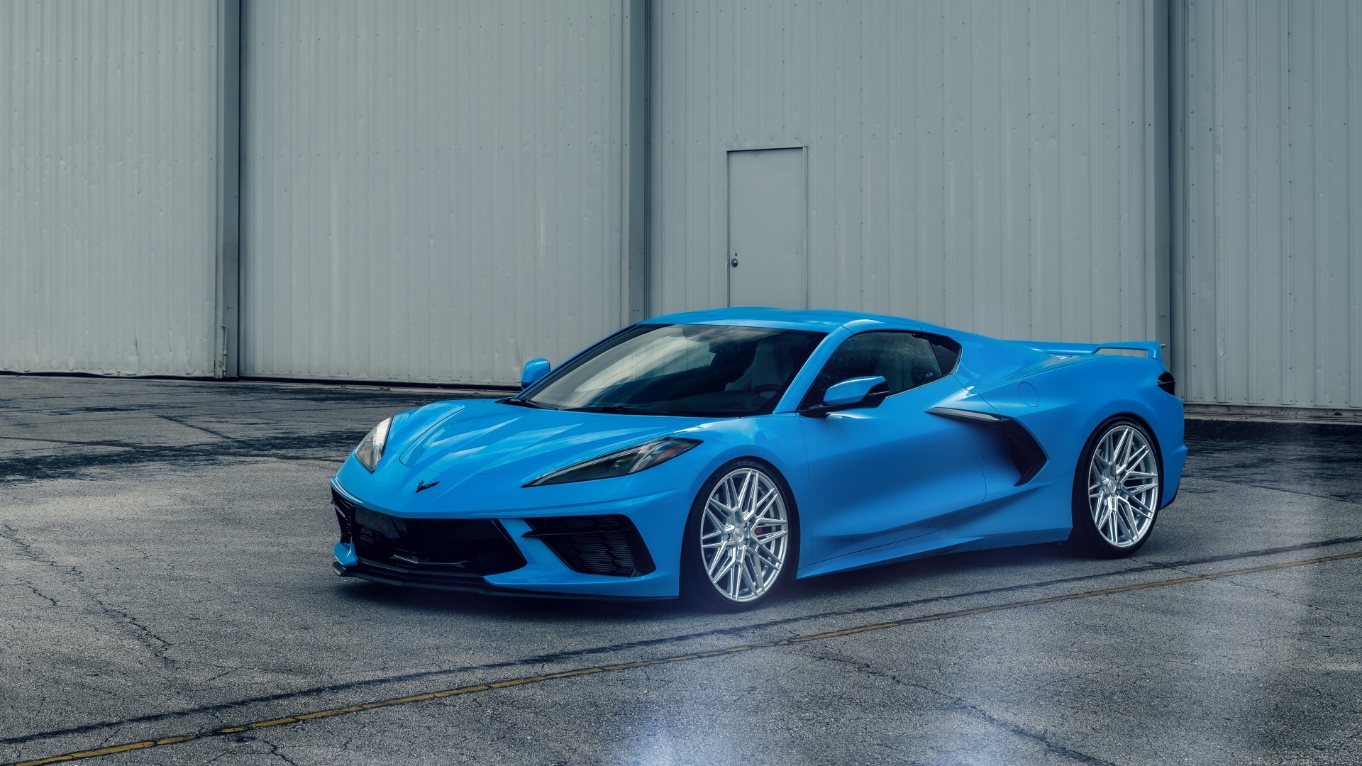 Синий Chevrolet Corvette C8 у серого здания