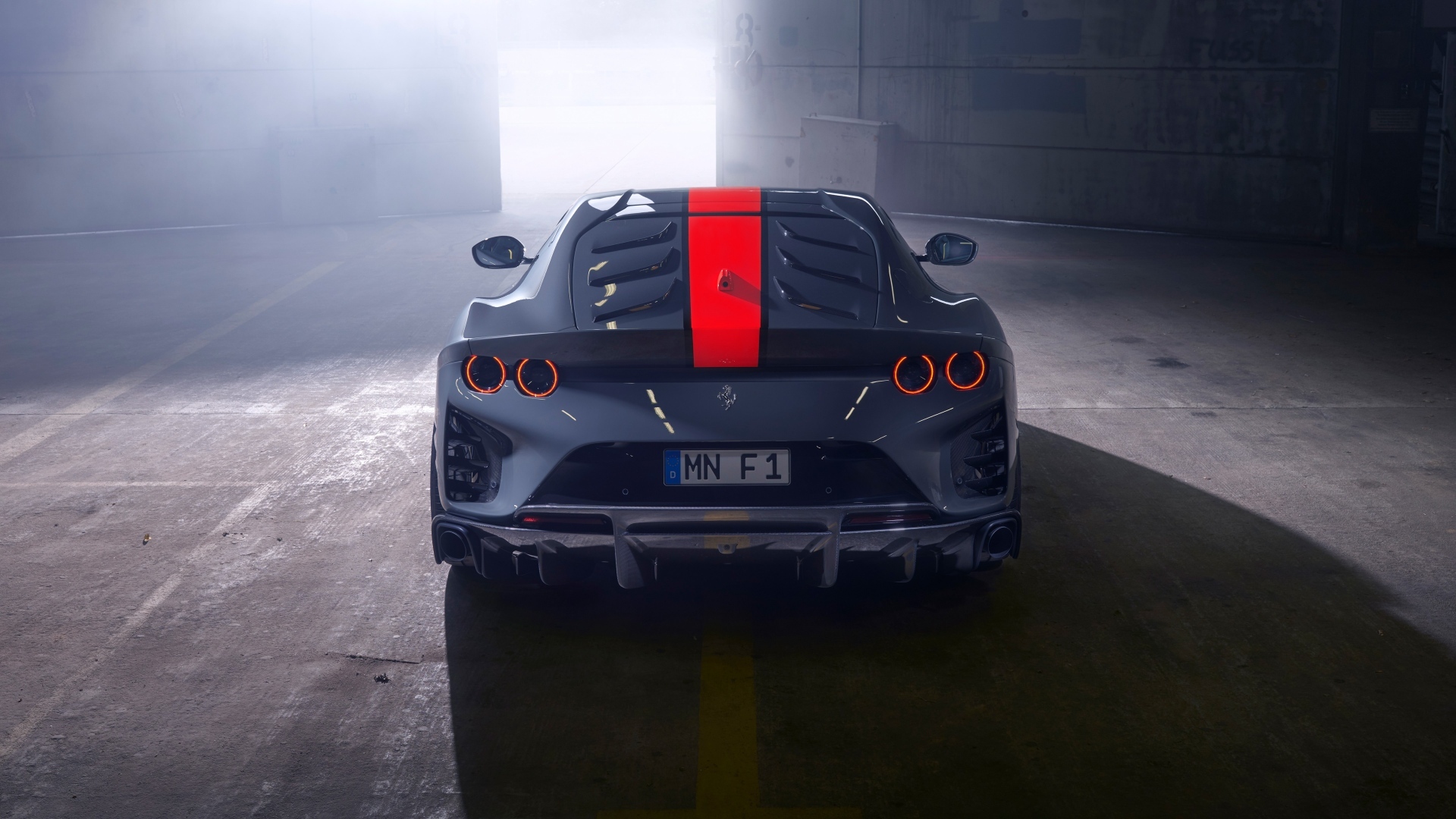 Серый спортивный автомобиль Ferrari 812 вид сзади