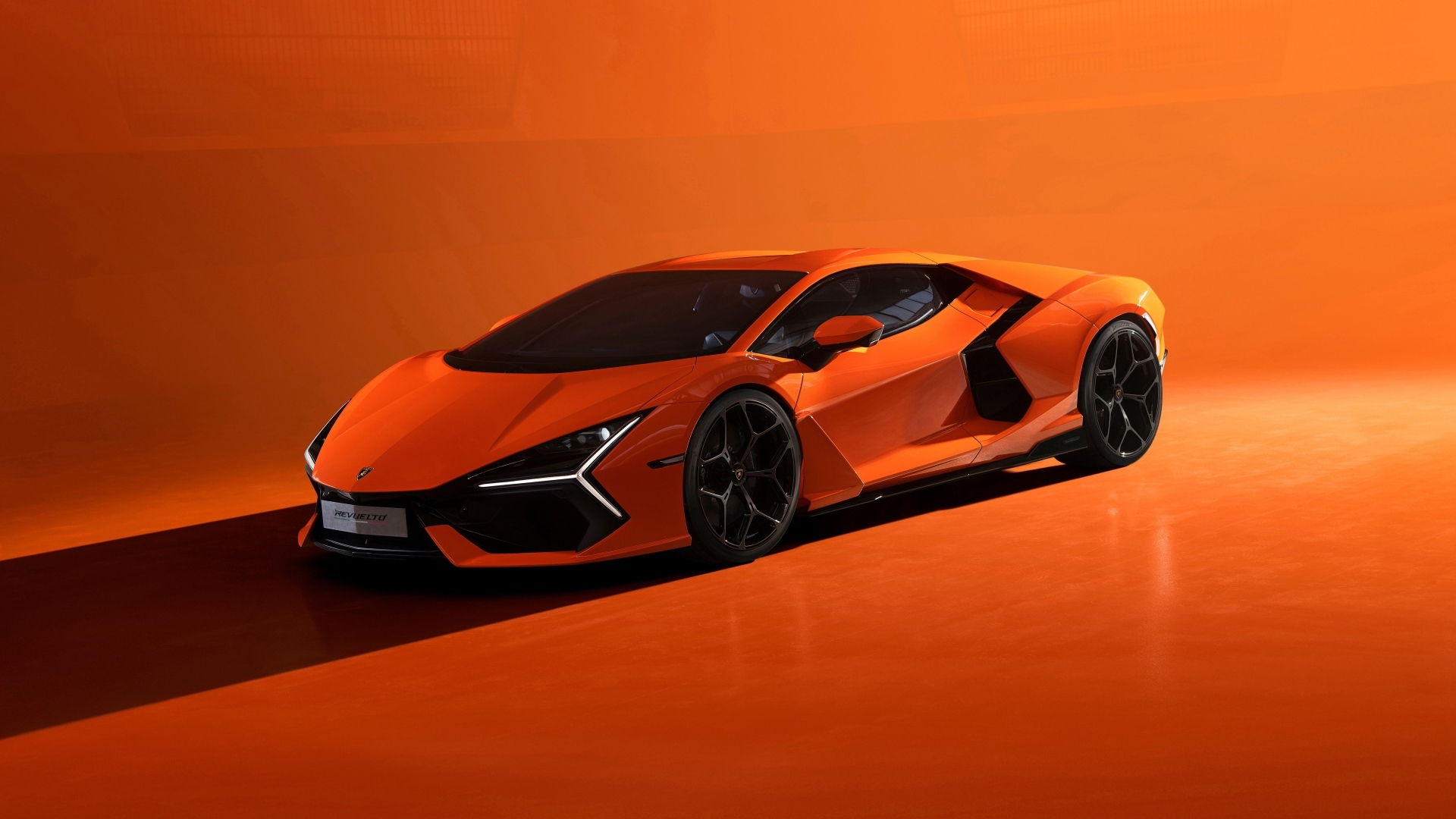 Автомобиль Lamborghini Revuelto 2023 года на оранжевом фоне