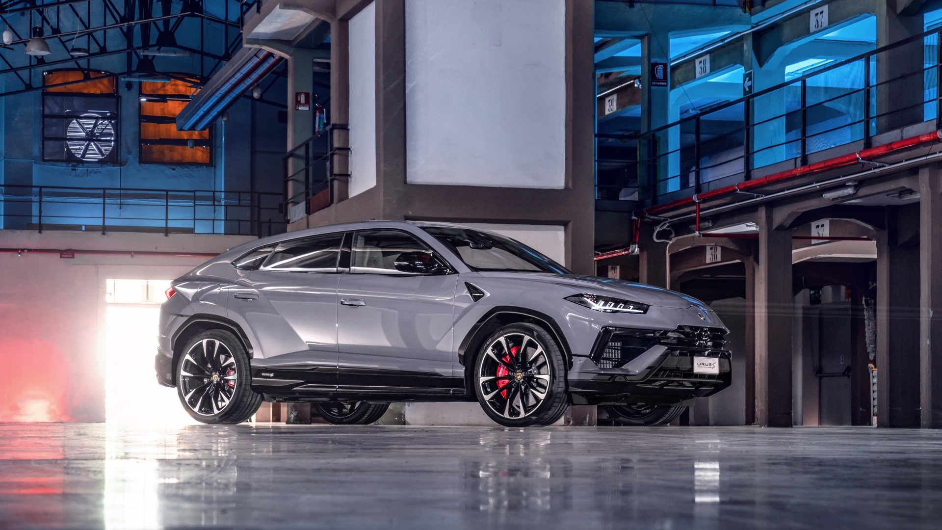 Серебристый автомобиль Lamborghini Urus S в здании