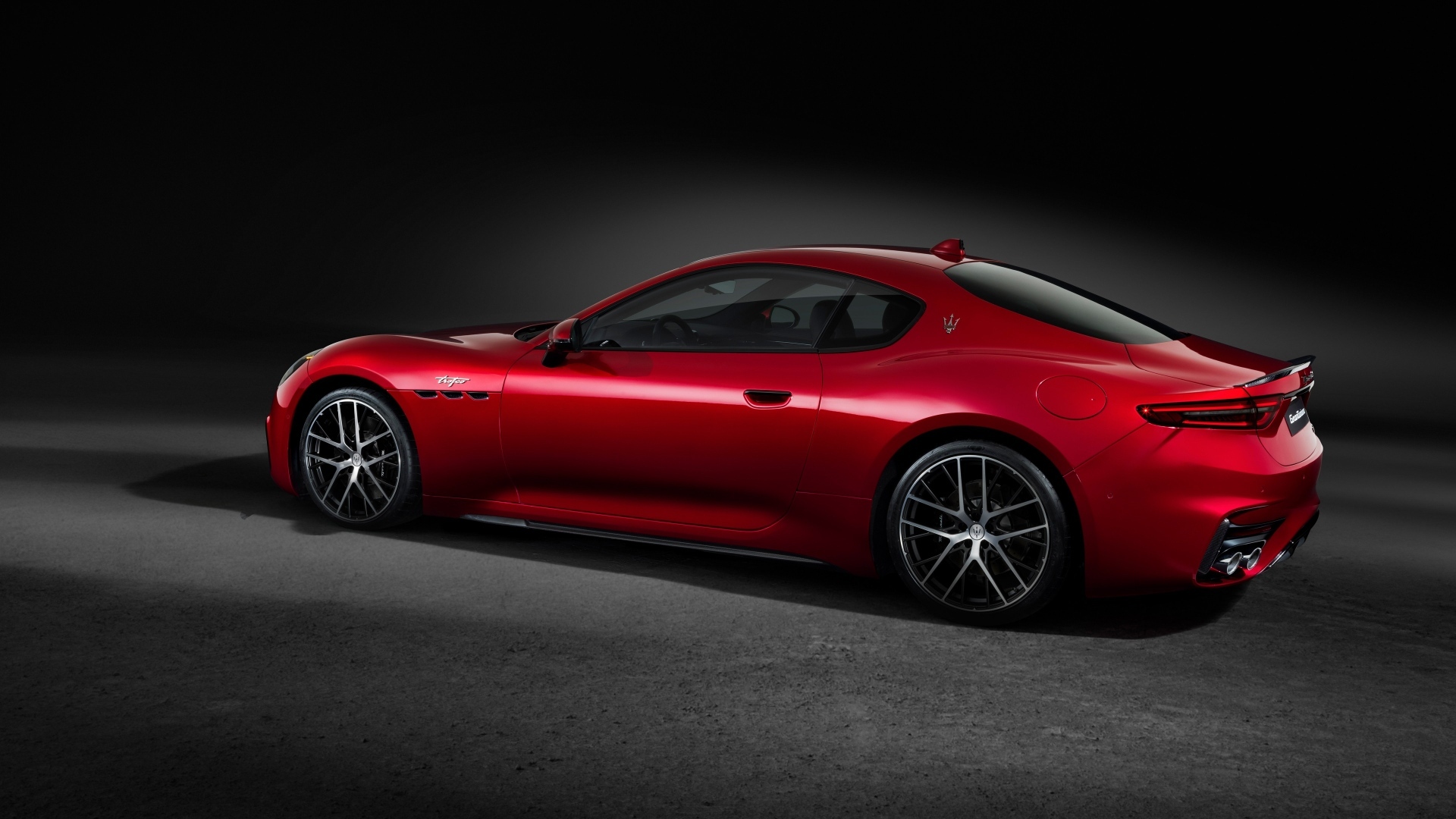 Красный автомобиль Maserati GranTurismo Trofeo 2023 на сером фоне