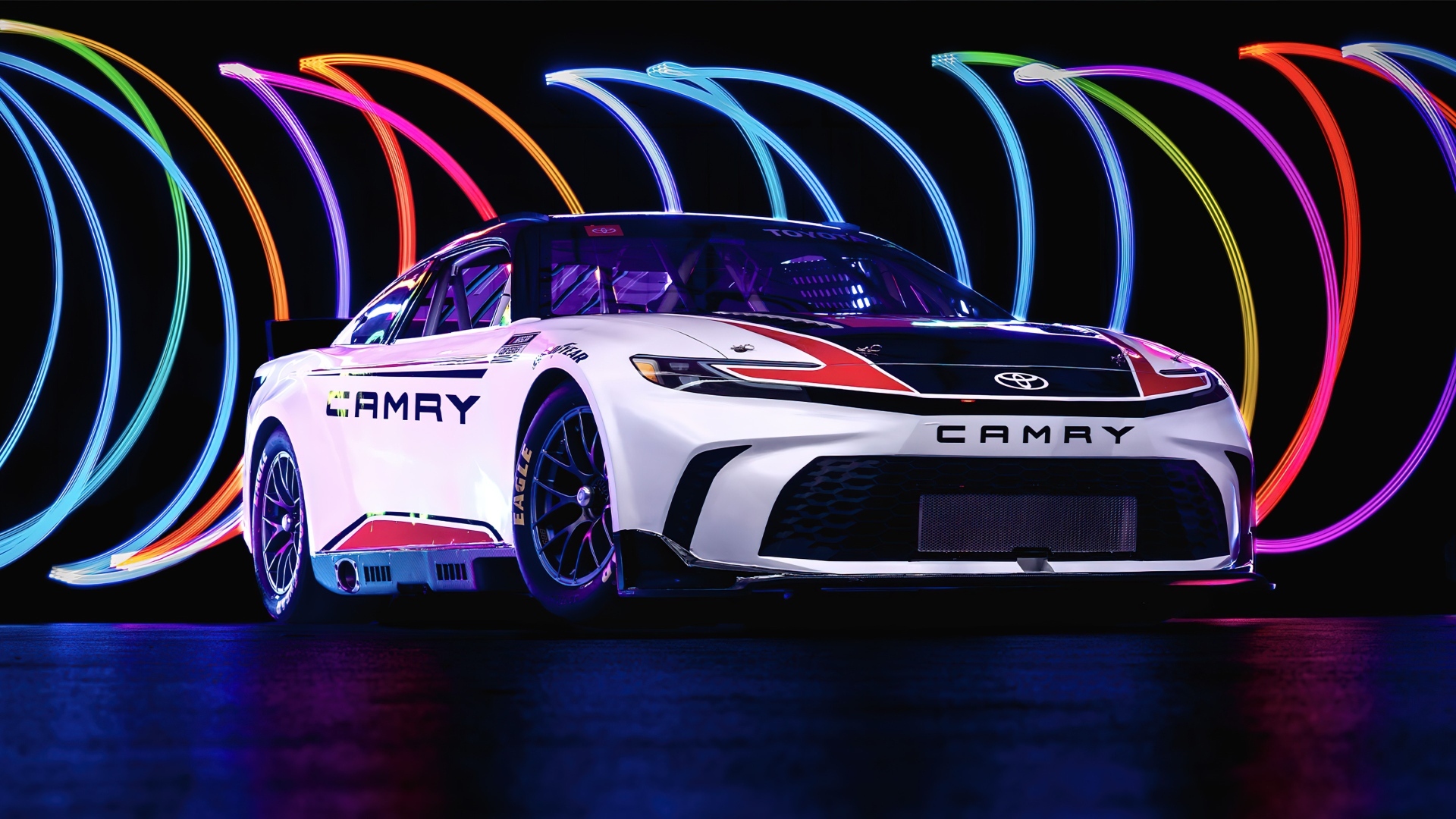 Автомобиль Toyota Camry XSE NASCAR Race Car 2024  года на разноцветном фоне