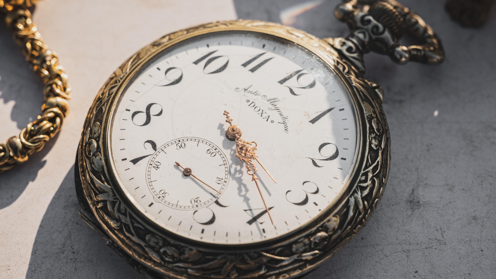 Старые карманные часы с золотыми стрелками