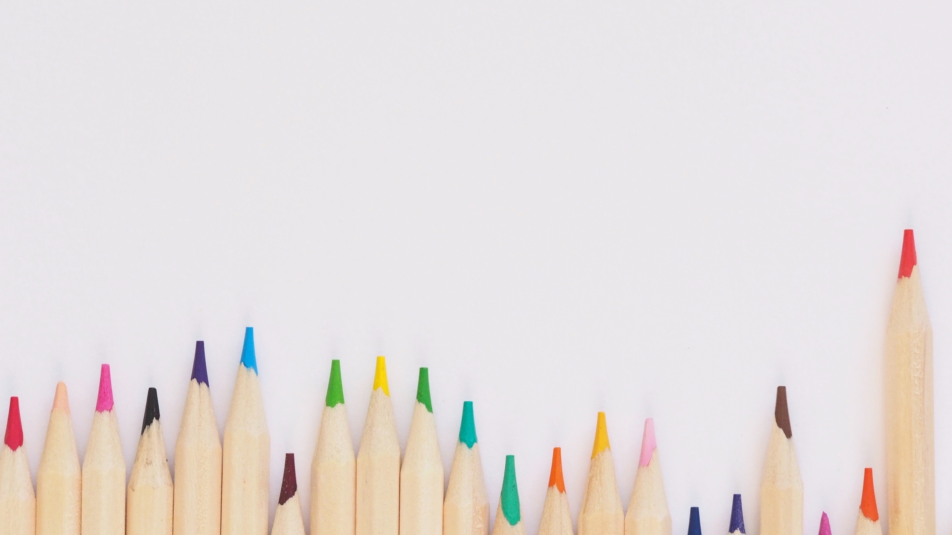 Острые разноцветные карандаши на сером фоне