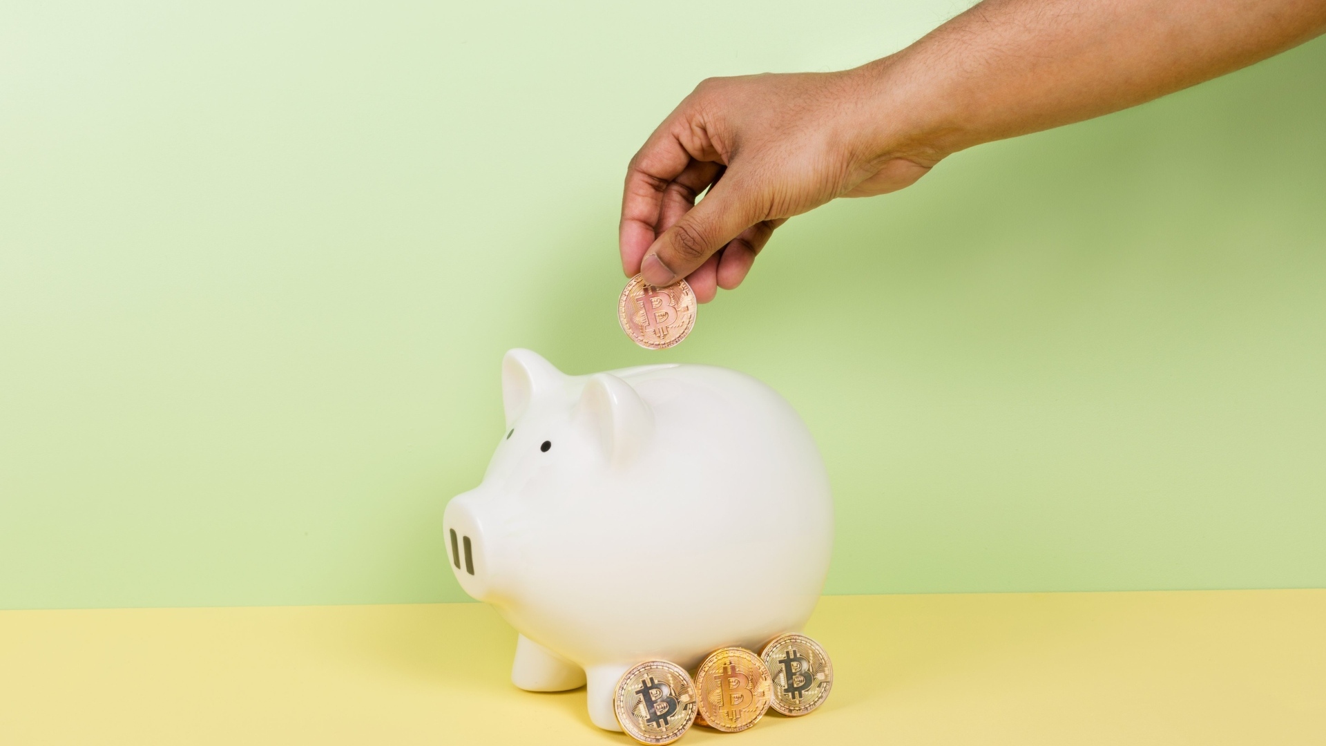 Рука бросает монету в свинью копилку