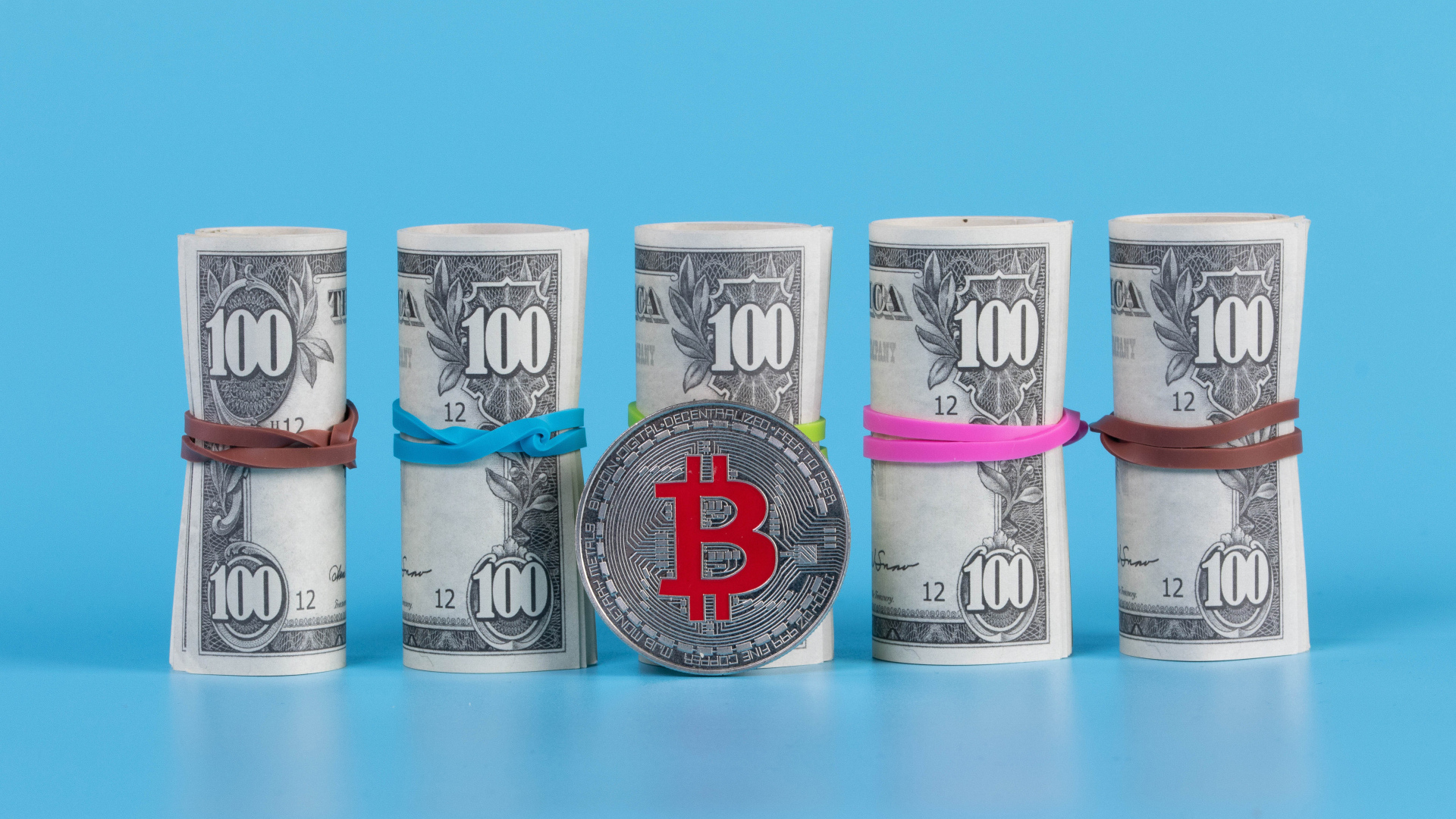 Доллары с монетой биткоин на голубом фоне