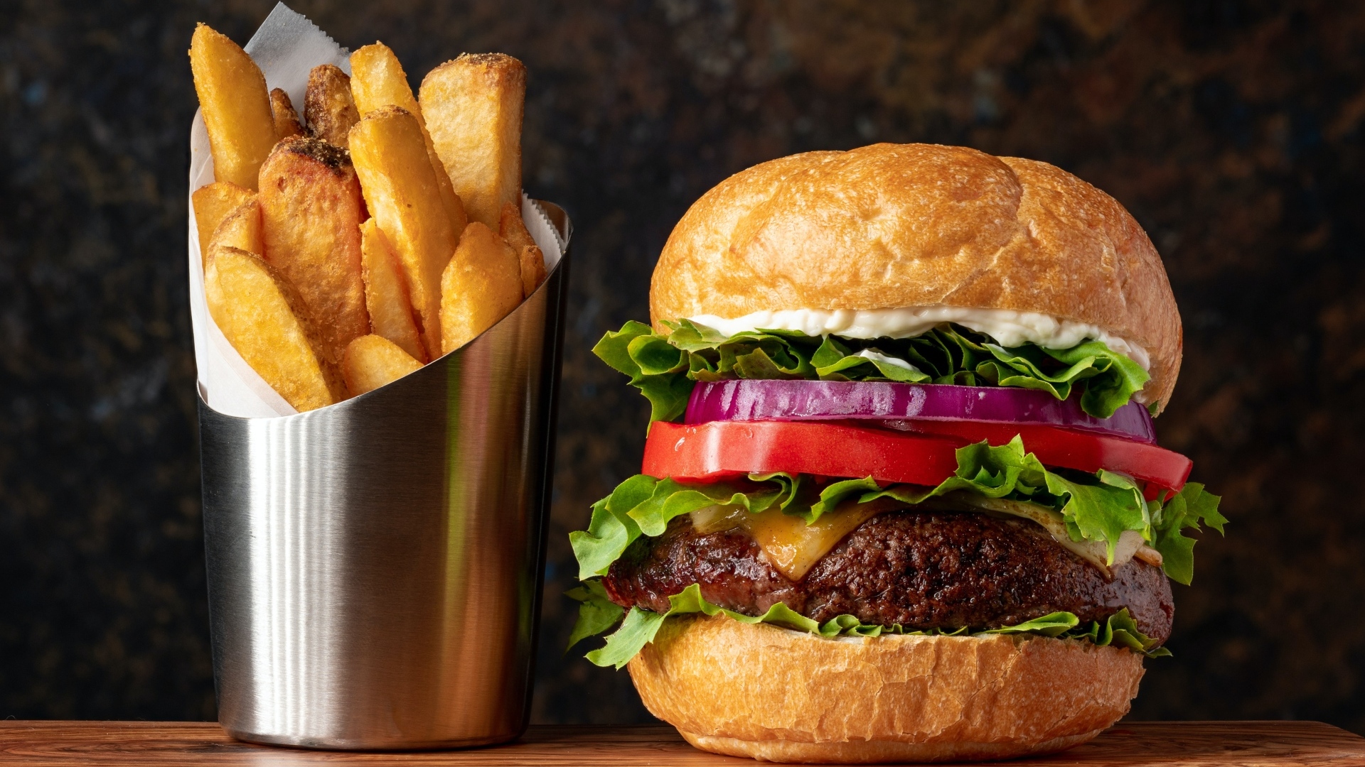 Большой гамбургер на столе с картофелем фри