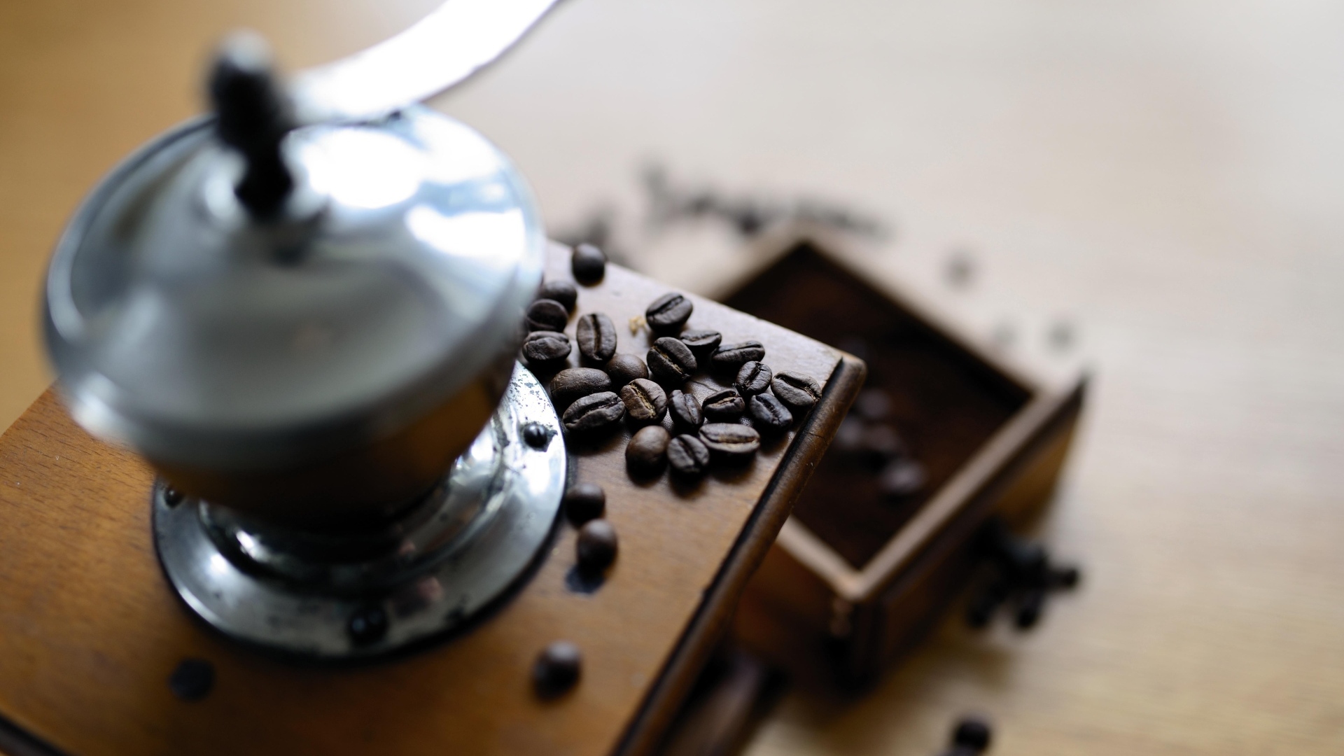 Кофемолка на столе с зернами