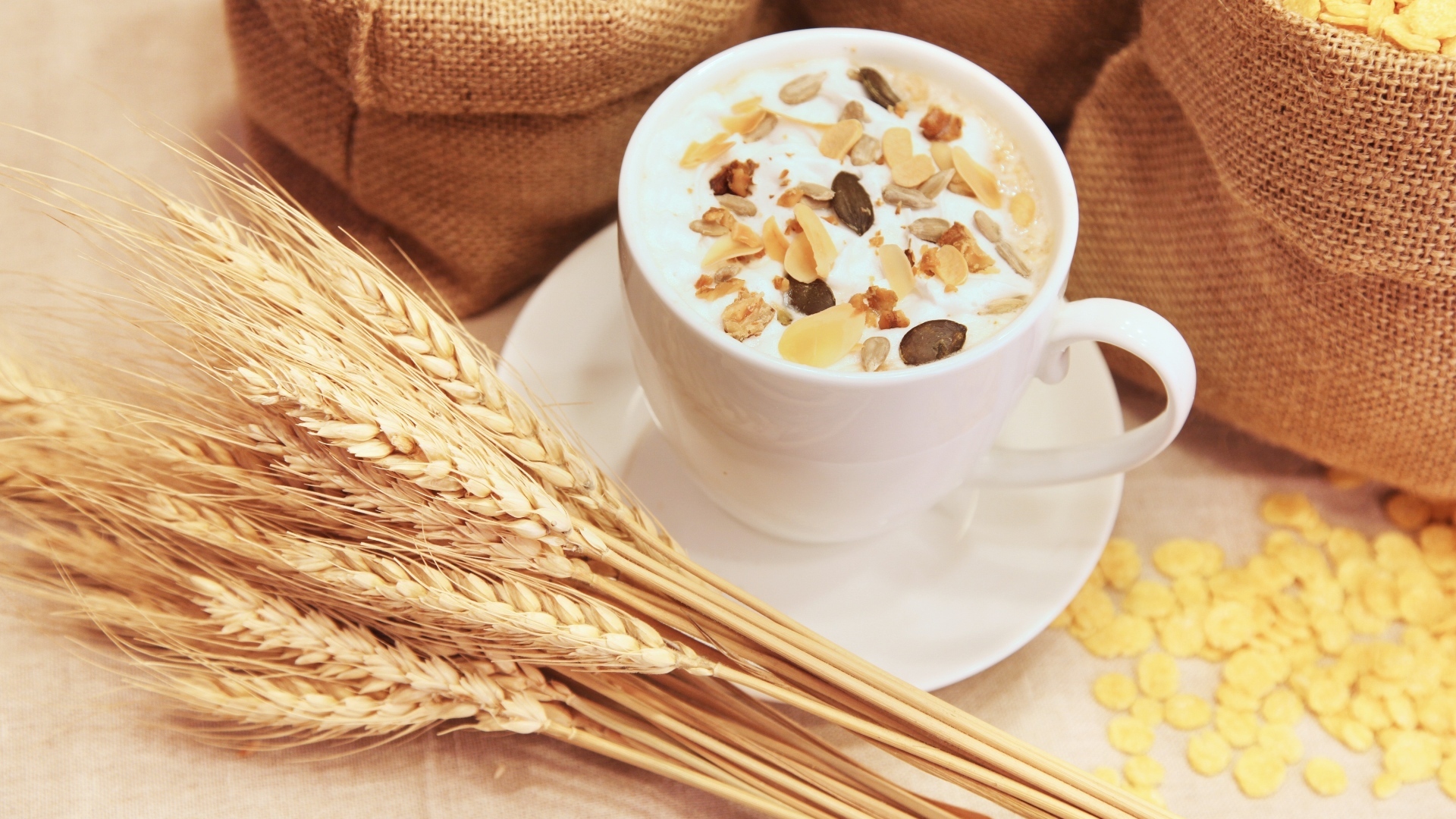 Cup of milk with cereals on a table with wheat