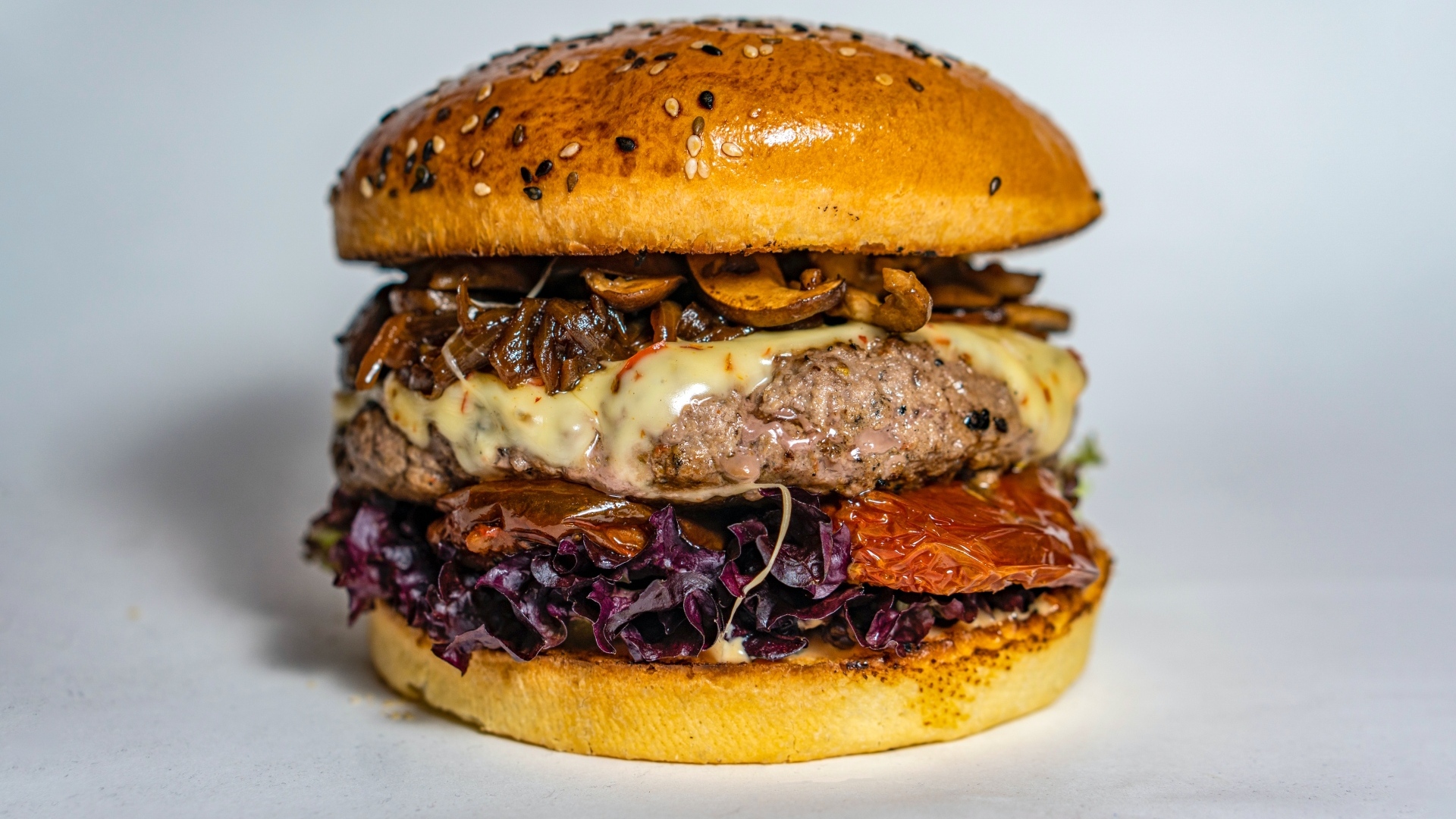 Ароматный сочный гамбургер на сером фоне крупным планом