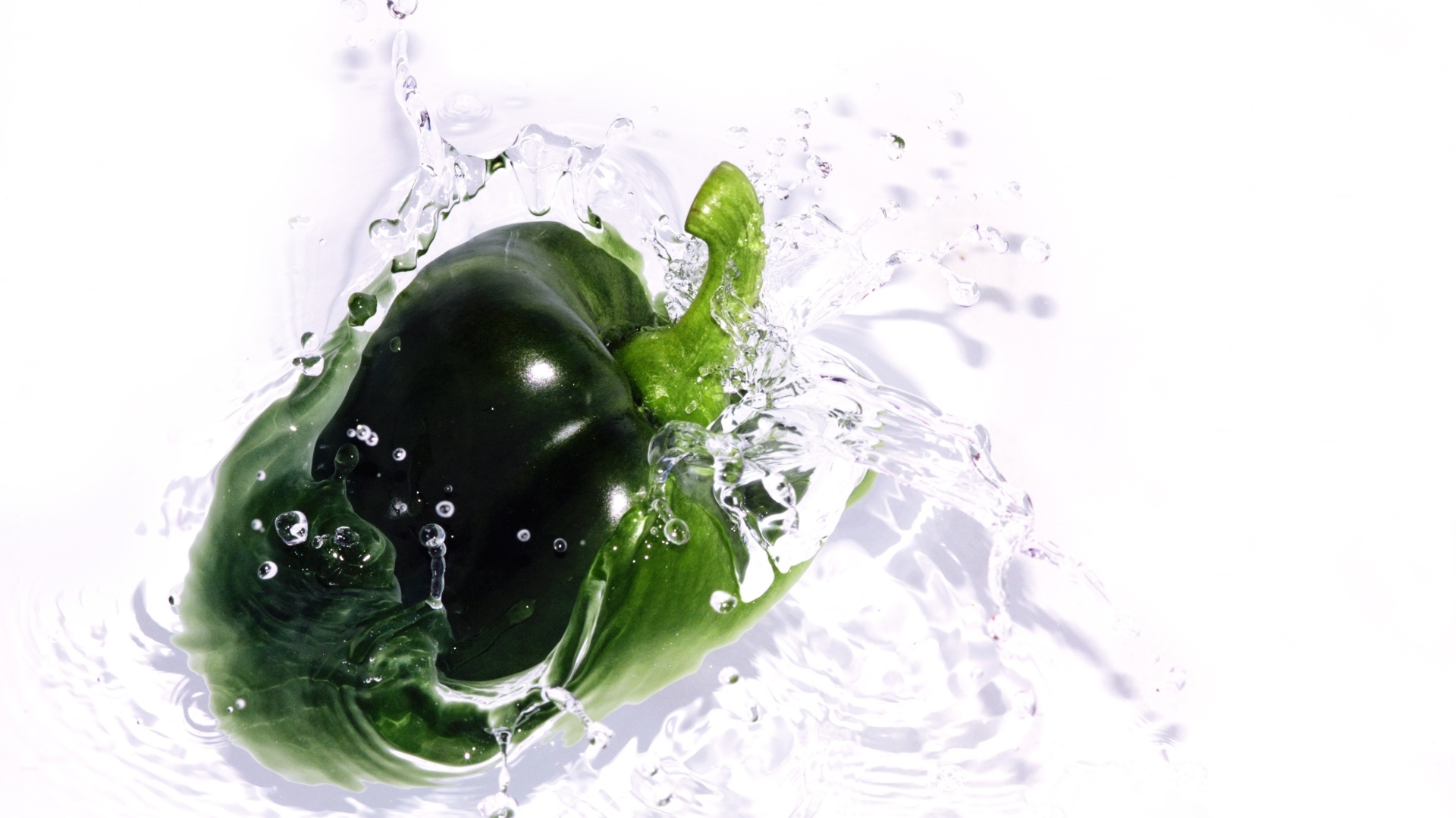 Зеленый перец в воде на белом фоне