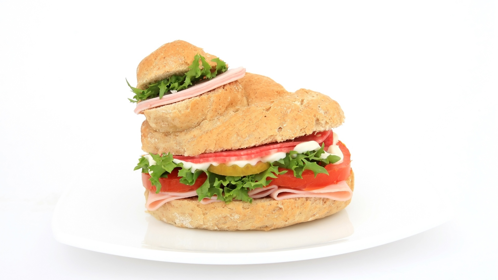 Гамбургер с колбасой, томатами и листьями салата на белом фоне