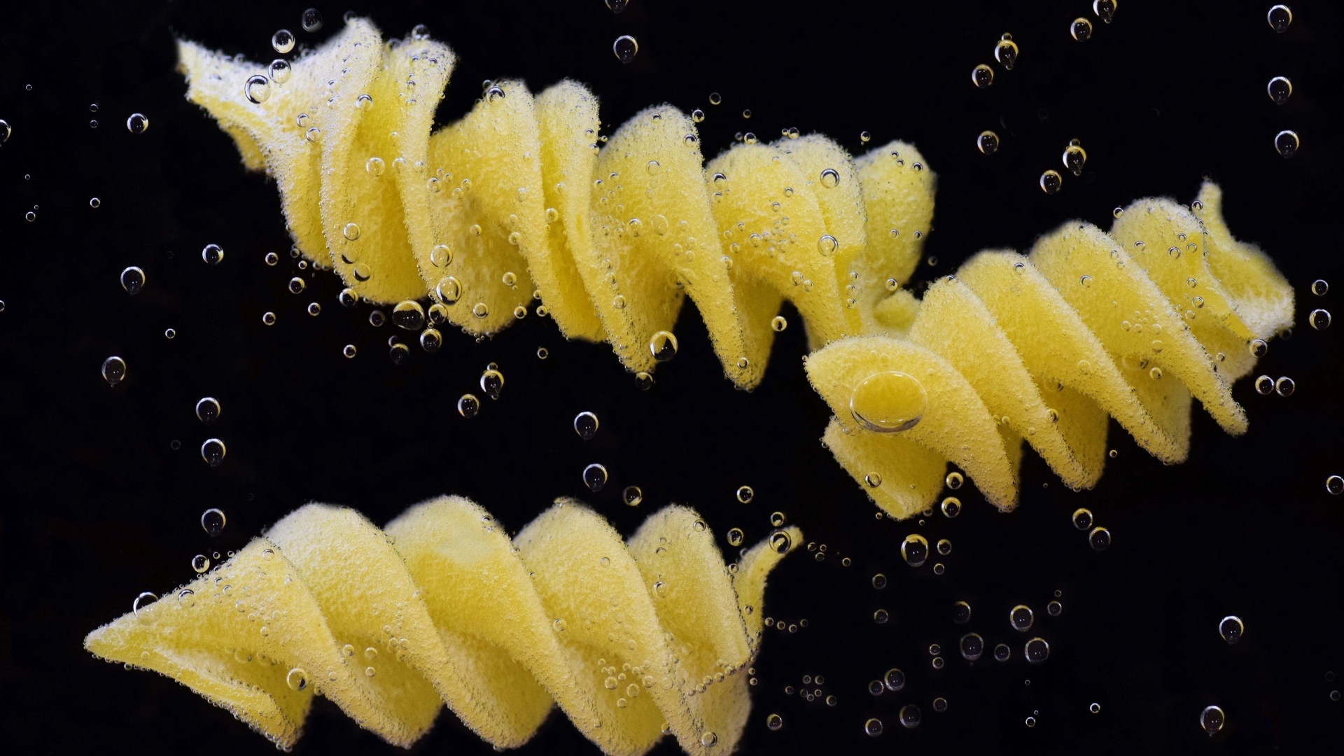 Макароны в воде на черном фоне