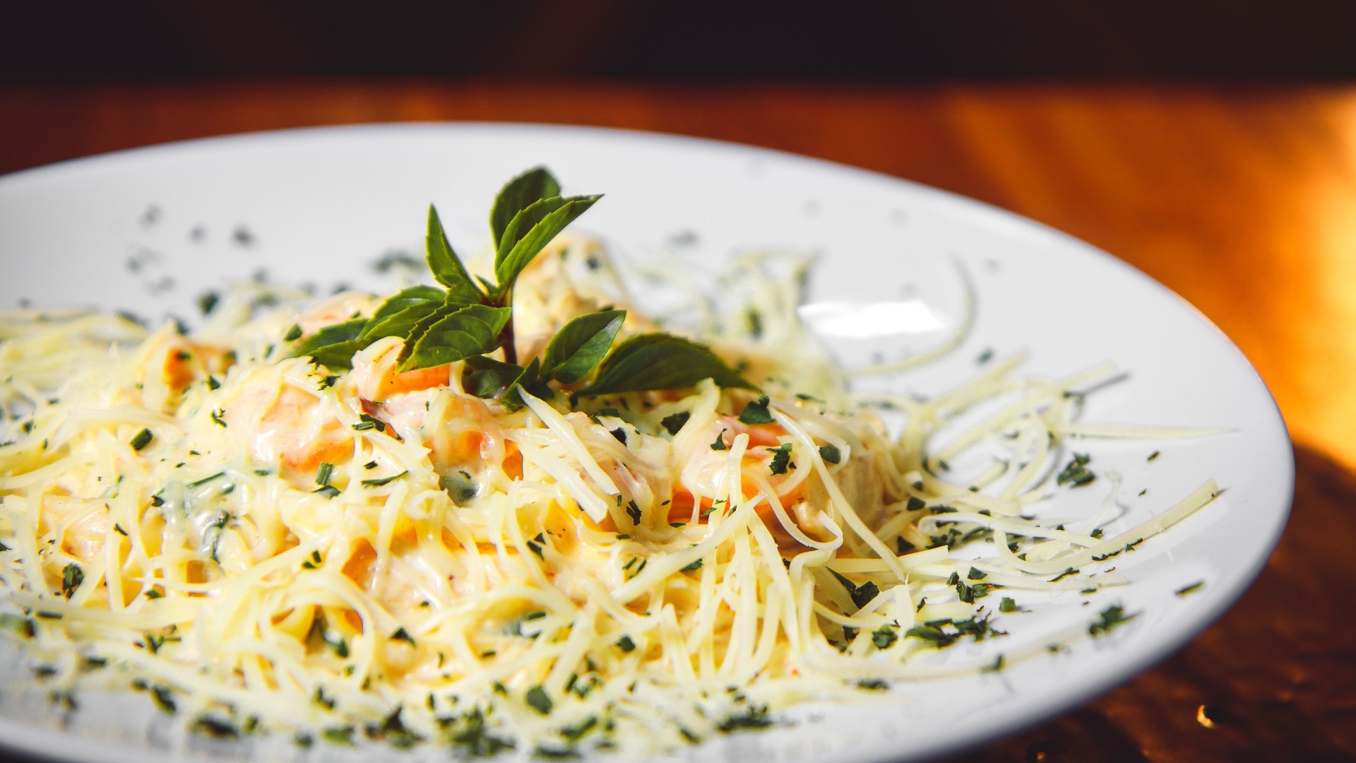 Спагетти с сыром и помидорами на белой тарелке