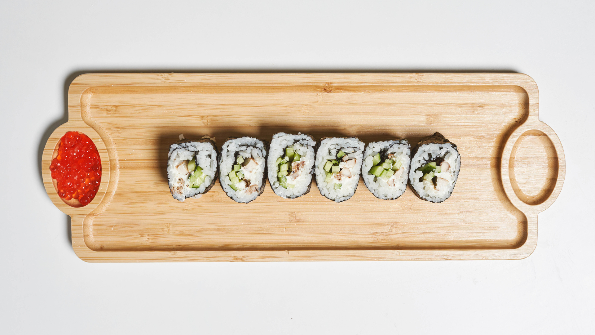 Суши на деревянной доске с  красной икрой