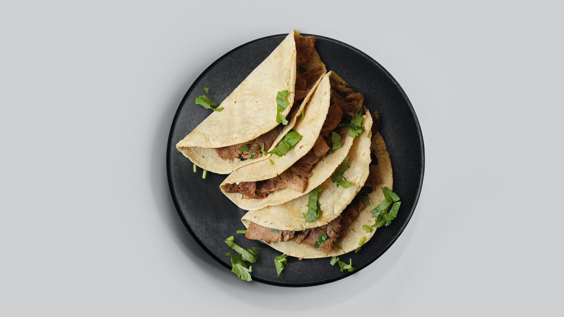 Блюдо тако в тарелке на сером фоне