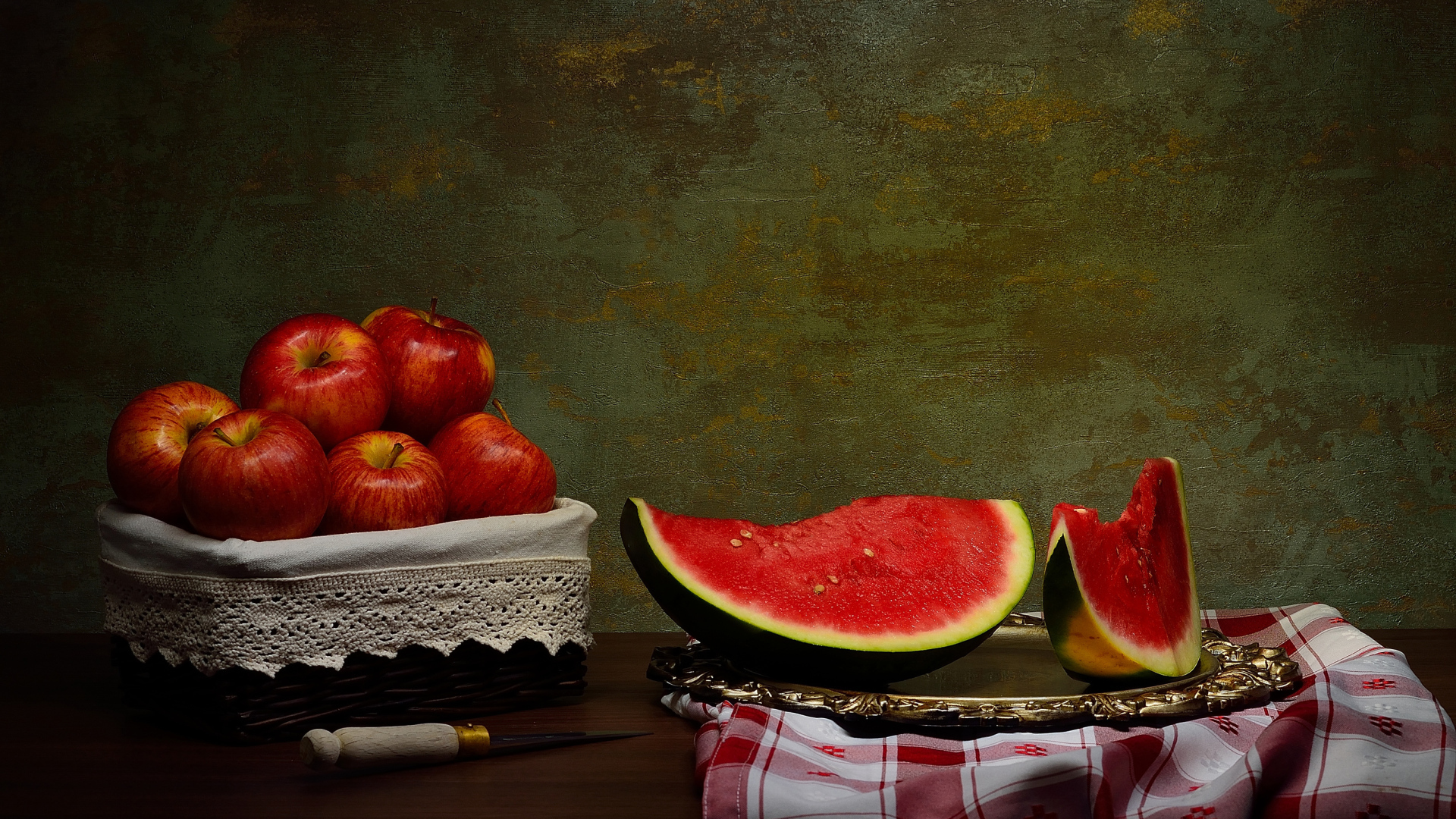 Скибки арбуза на столе с яблоками 