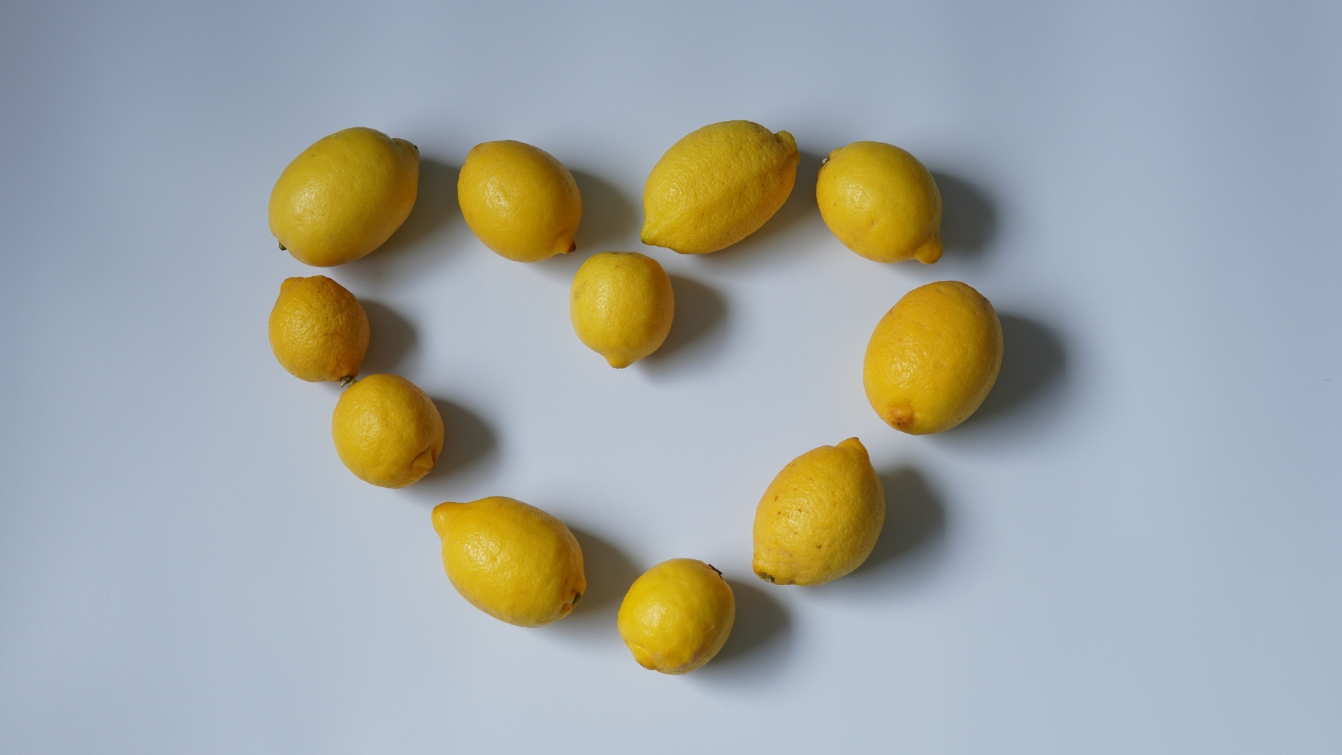 Сердце  из лимонов на сером фоне