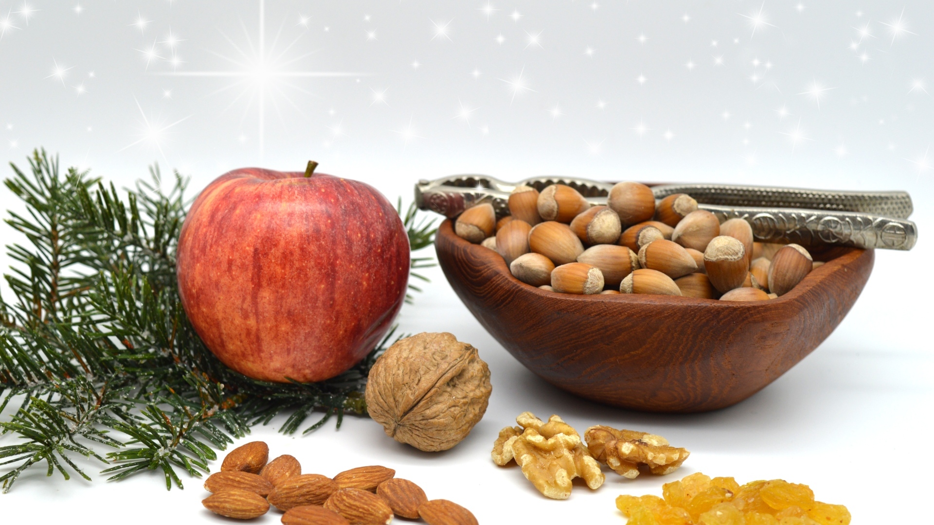 Орехи с яблоком и еловой веткой на столе
