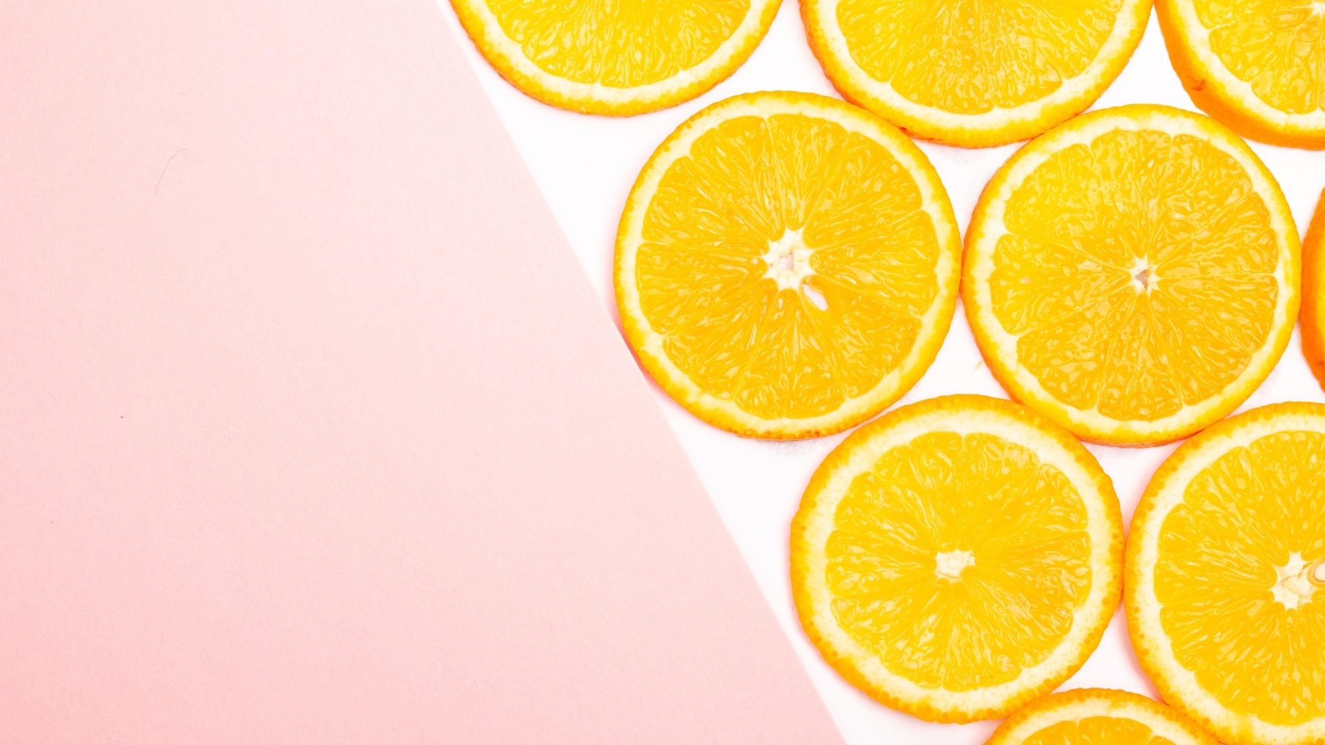 Кружочки апельсина на розовом фоне