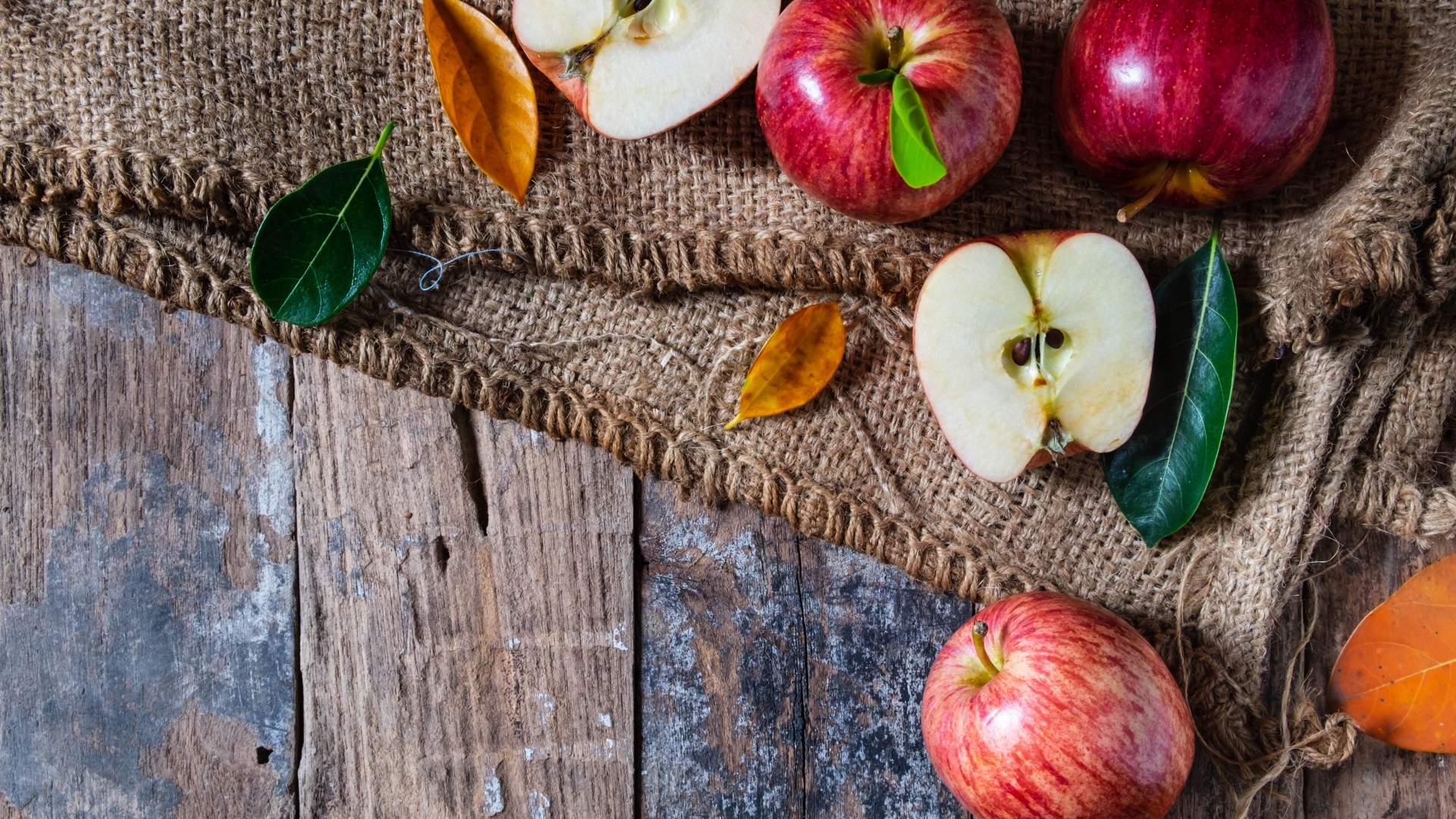 Спелые красные яблоки на столе с мешком