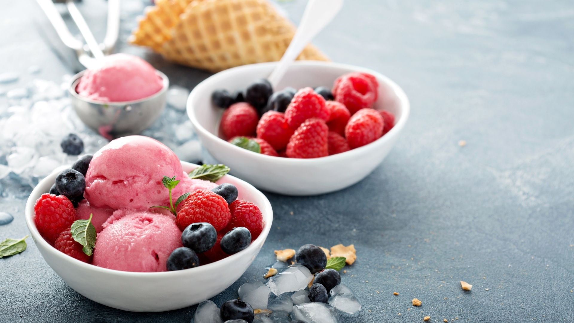 Сладкие ягоды с шариками мороженого на столе