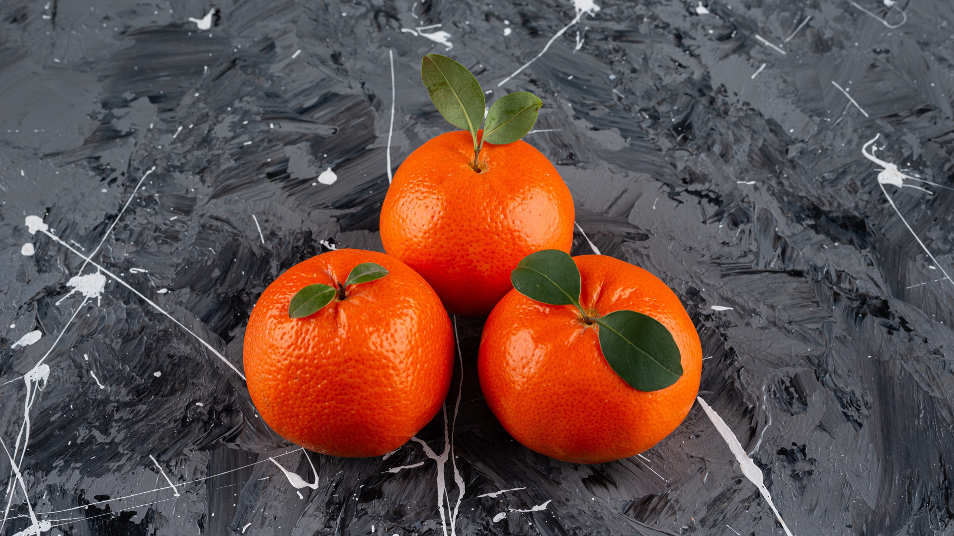 Три мандарина на сером столе