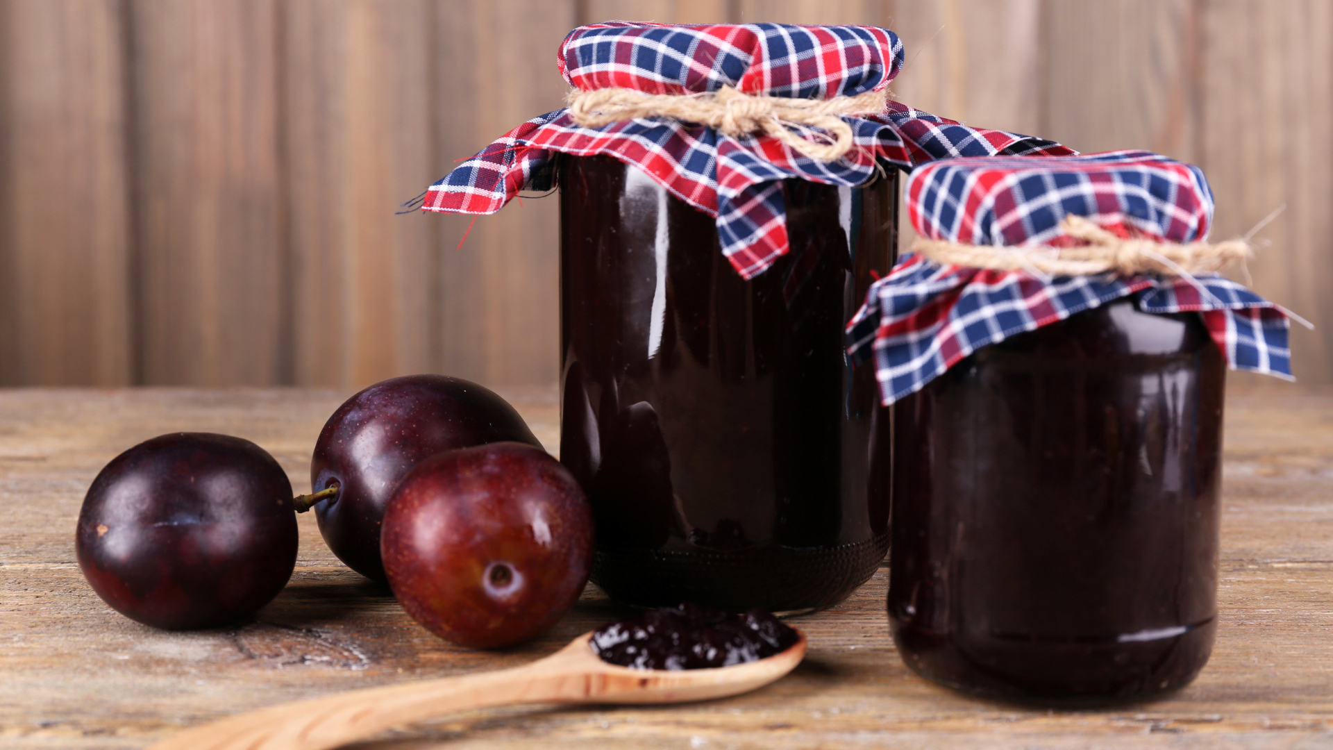 Две банки джема на столе со сливами