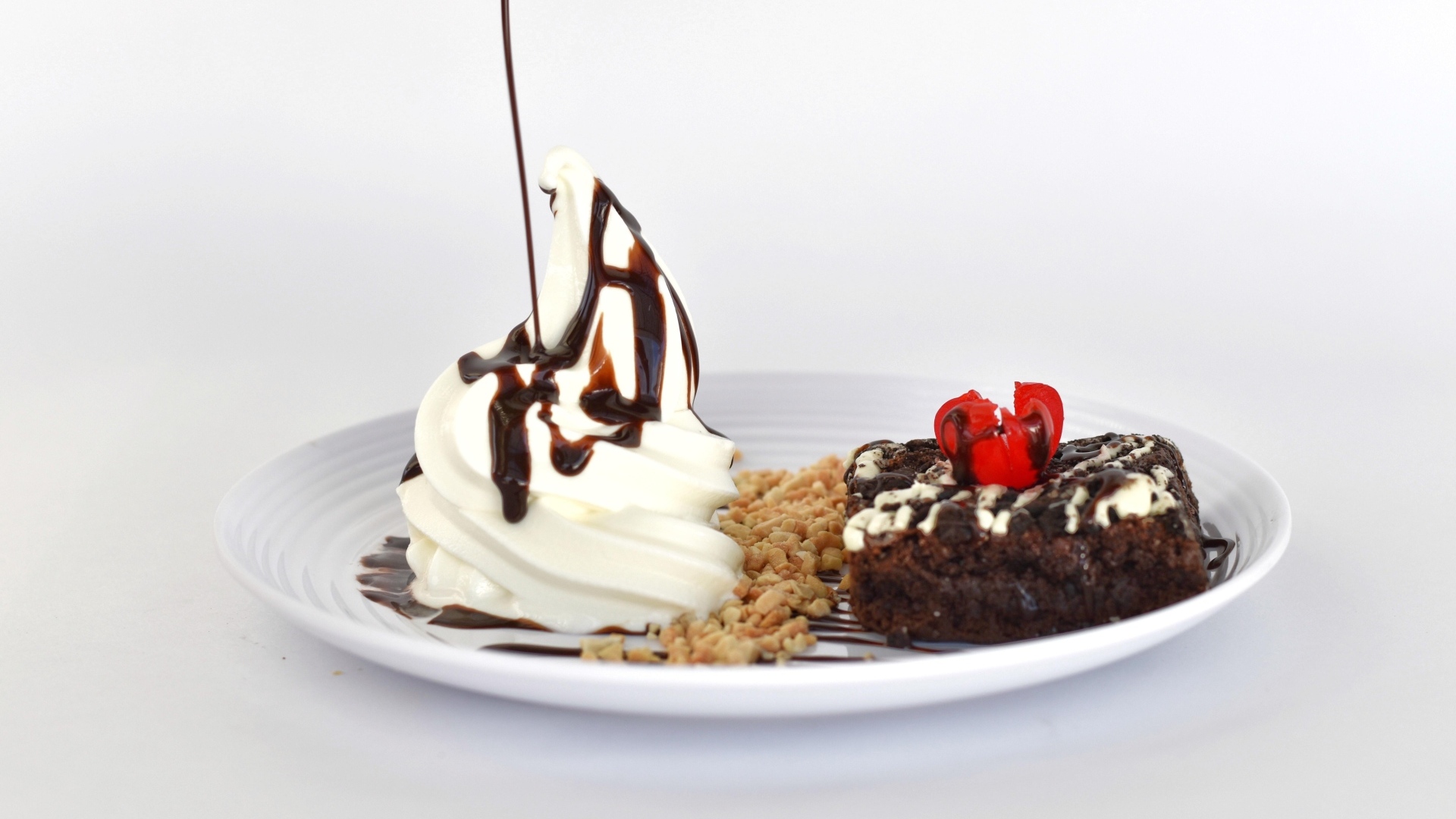 Пирожное со взбитыми сливками на тарелке на белом фоне