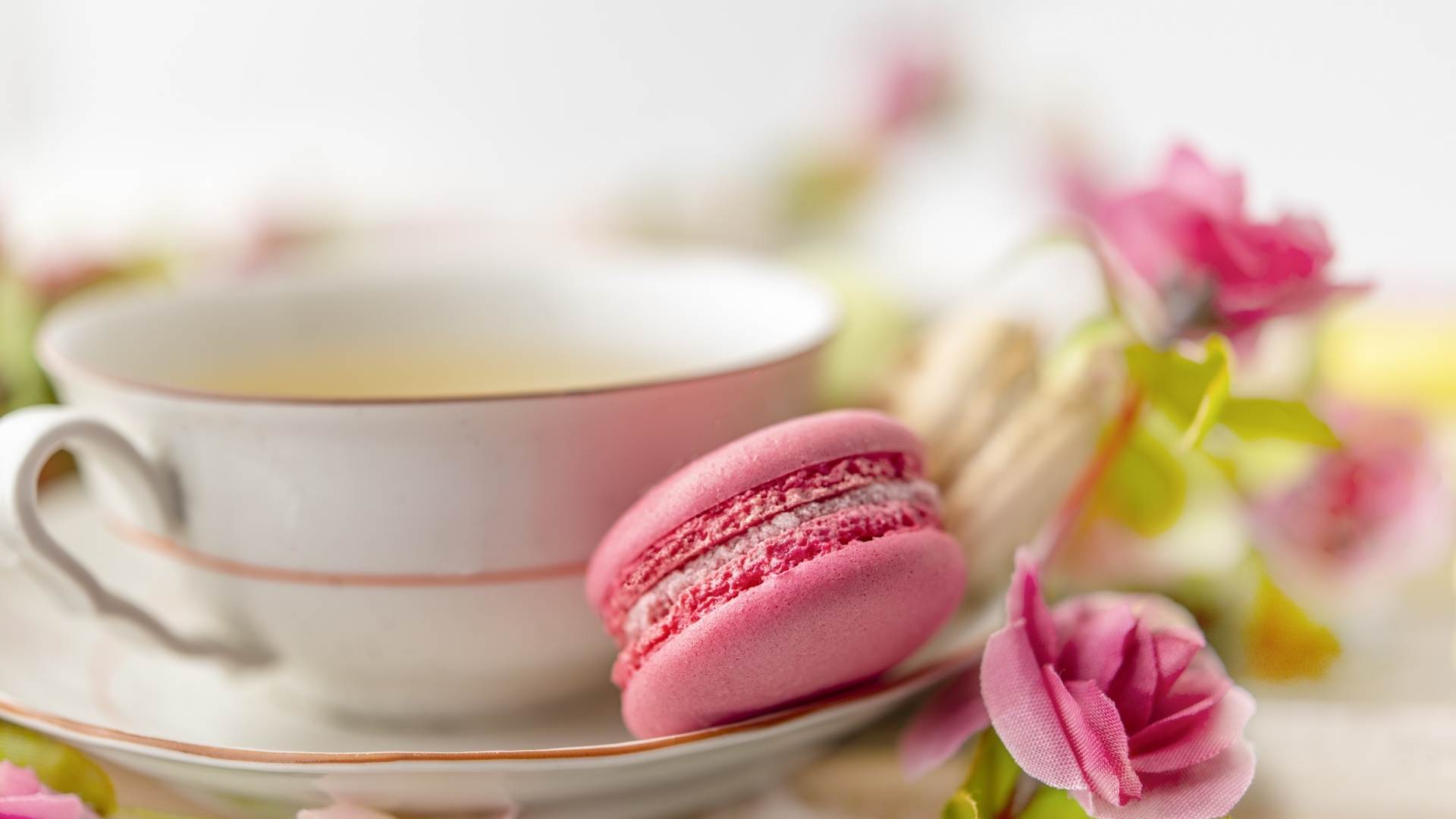 Чашка чая с десертом макарун и цветами розы