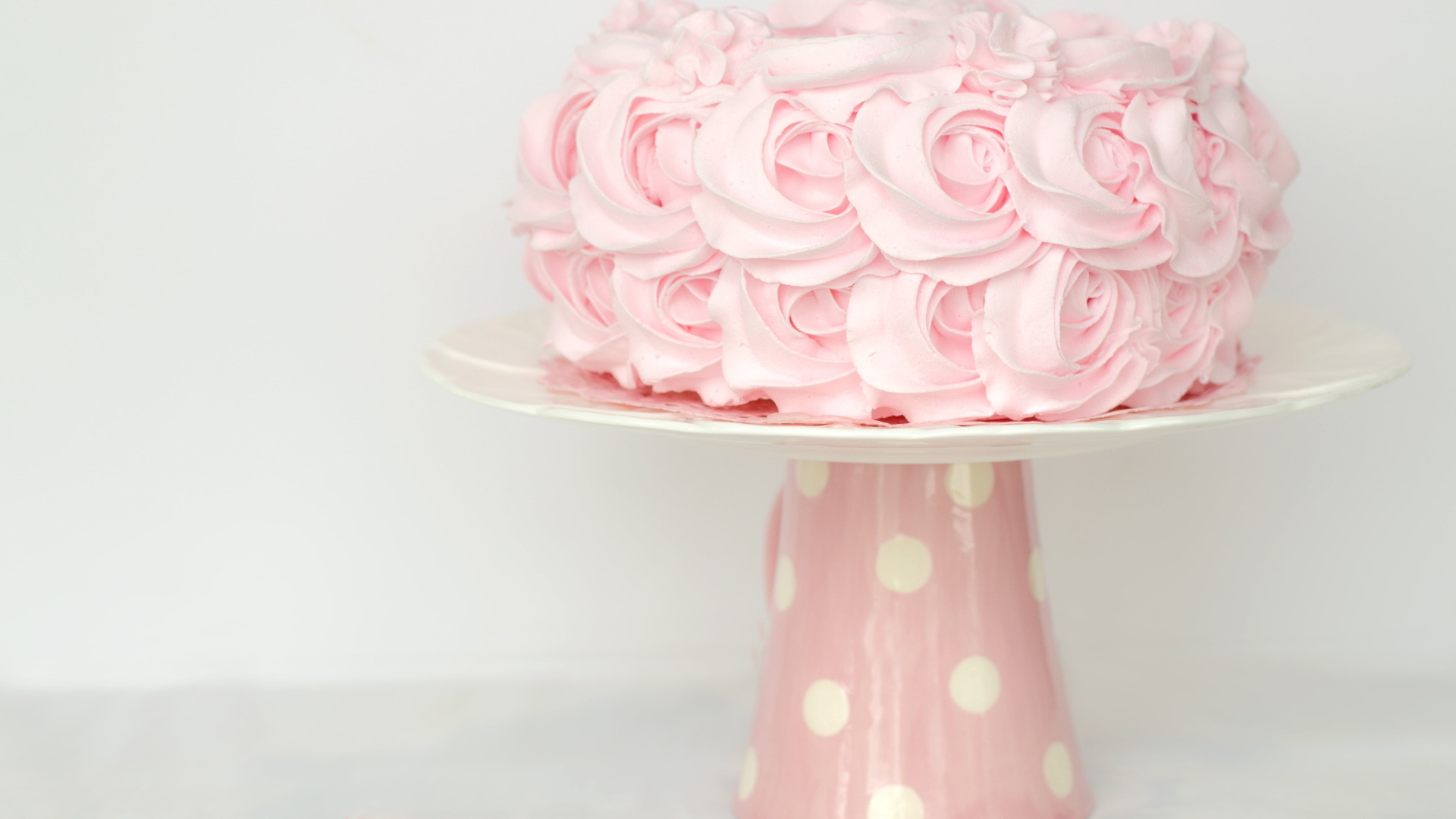 Розовый праздничный торт на столе