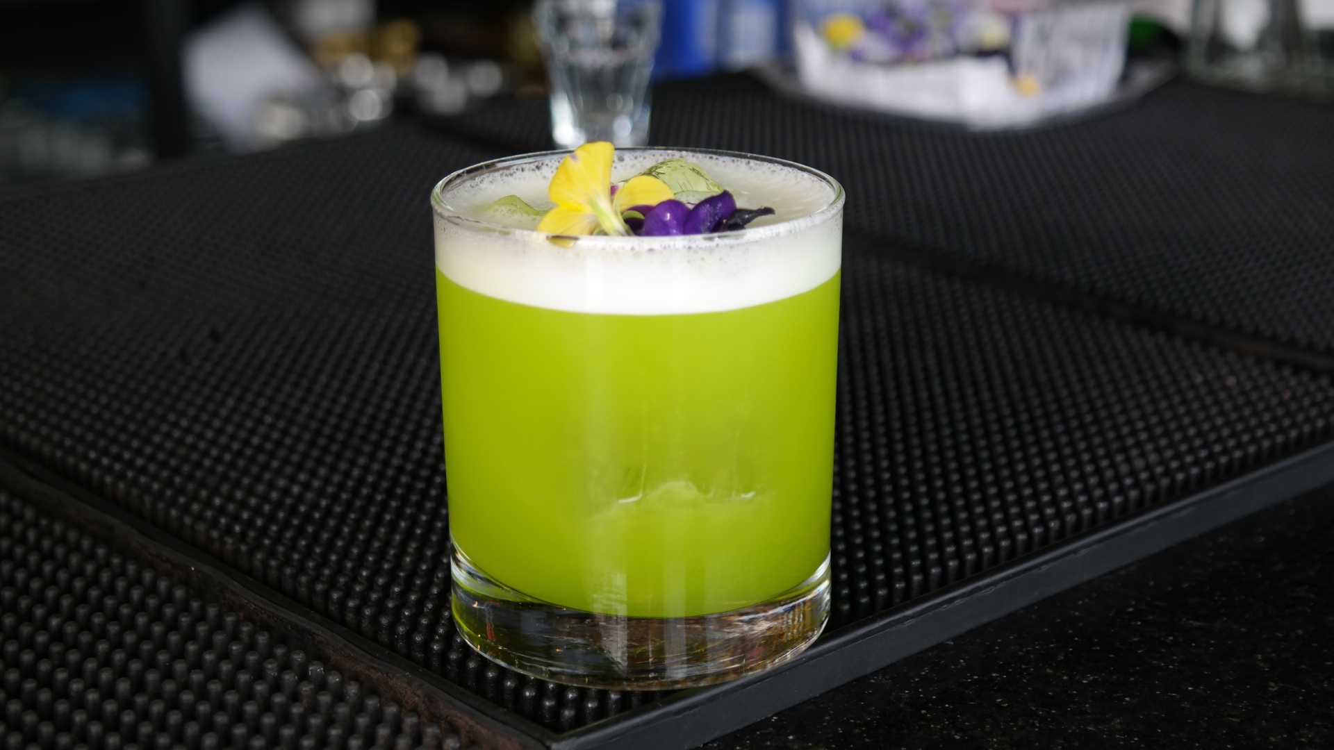 Зеленый коктейль в стакане с цветами