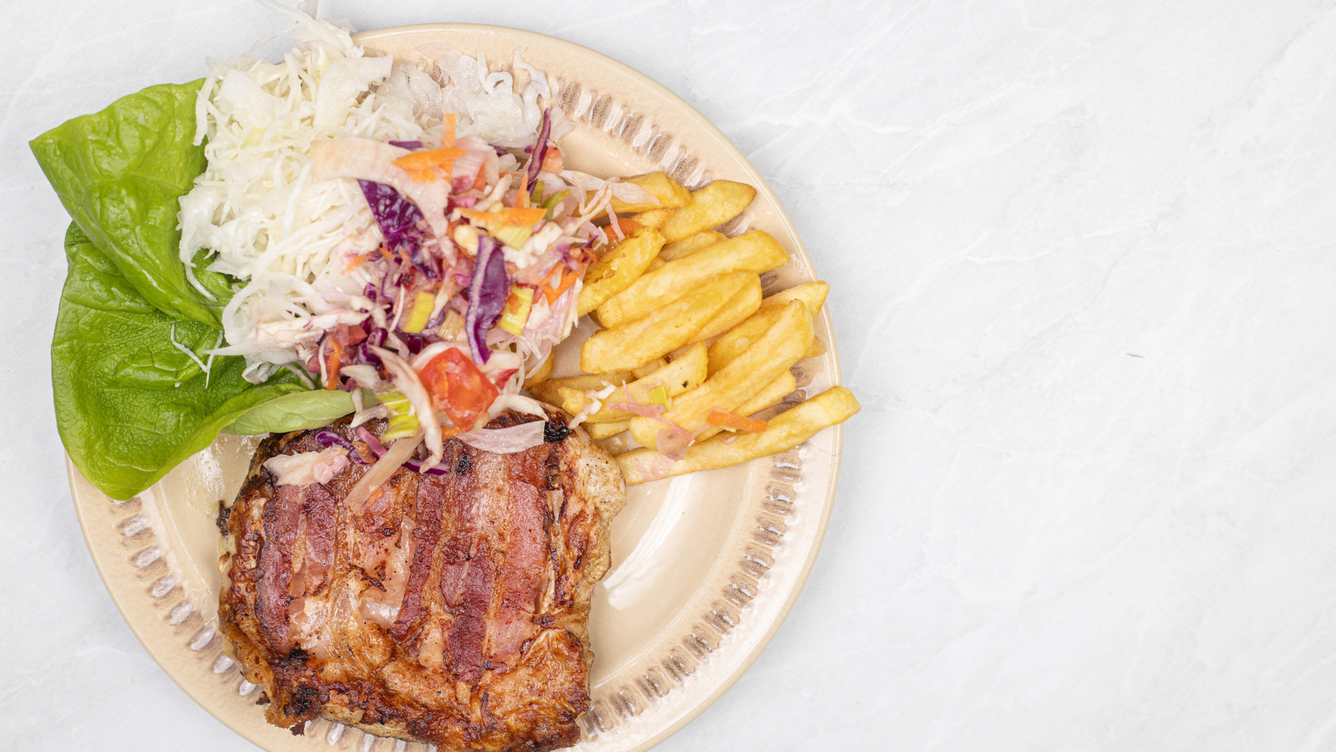 Meat on a plate with french fries and salad