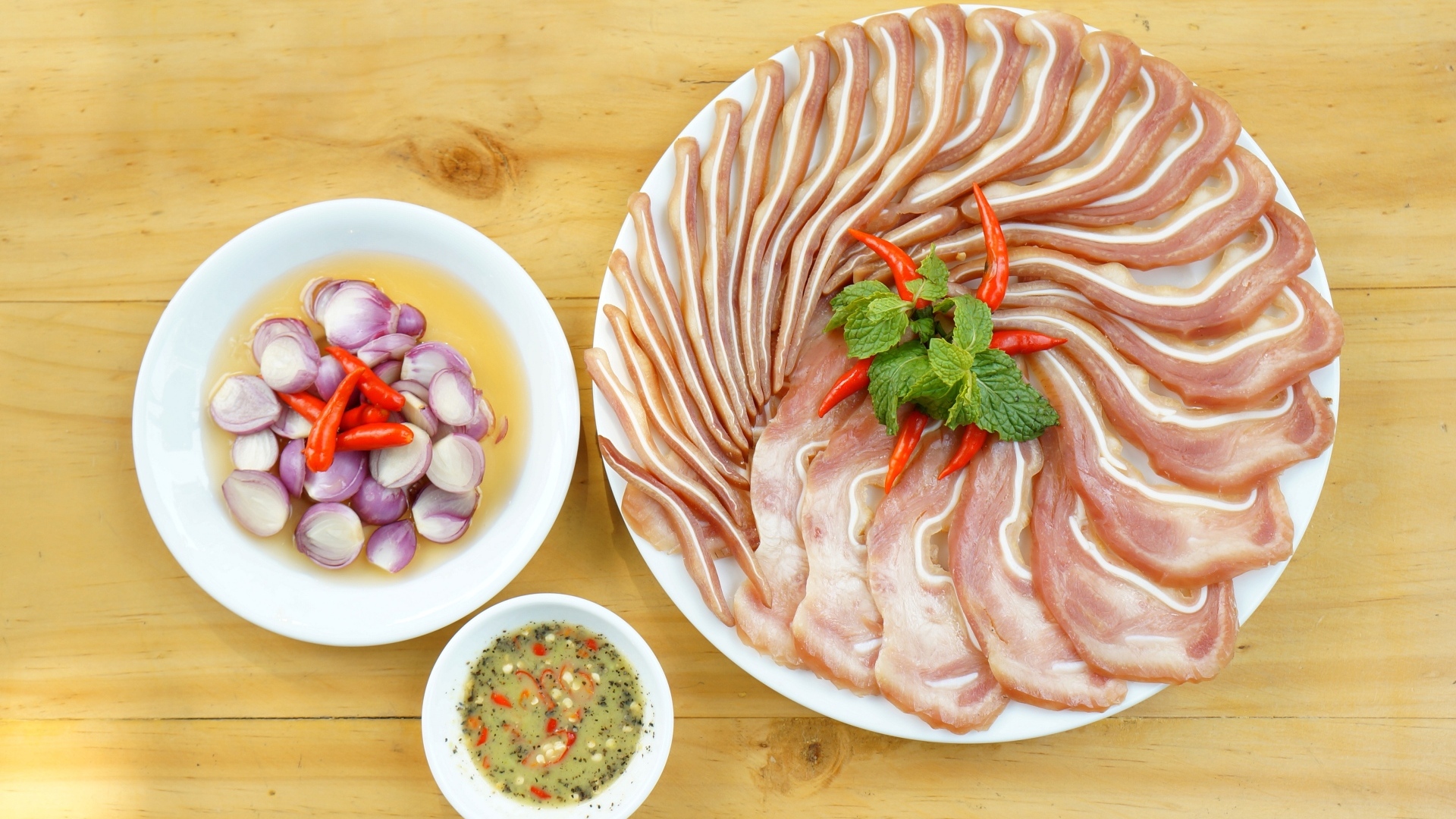 Smoked pork ears on the table with onions and sauce