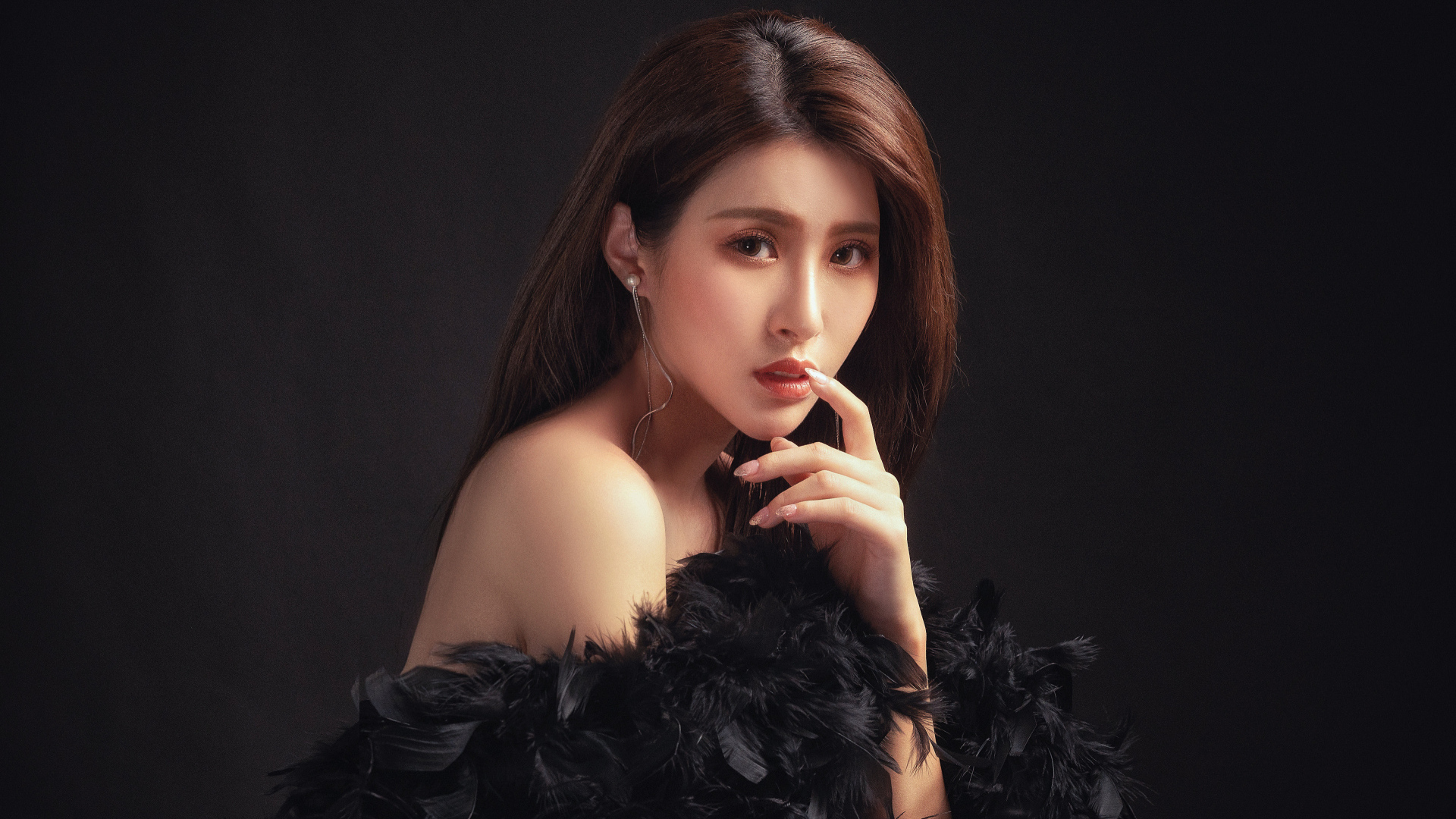 Девушка азиатка в боа на черном фоне