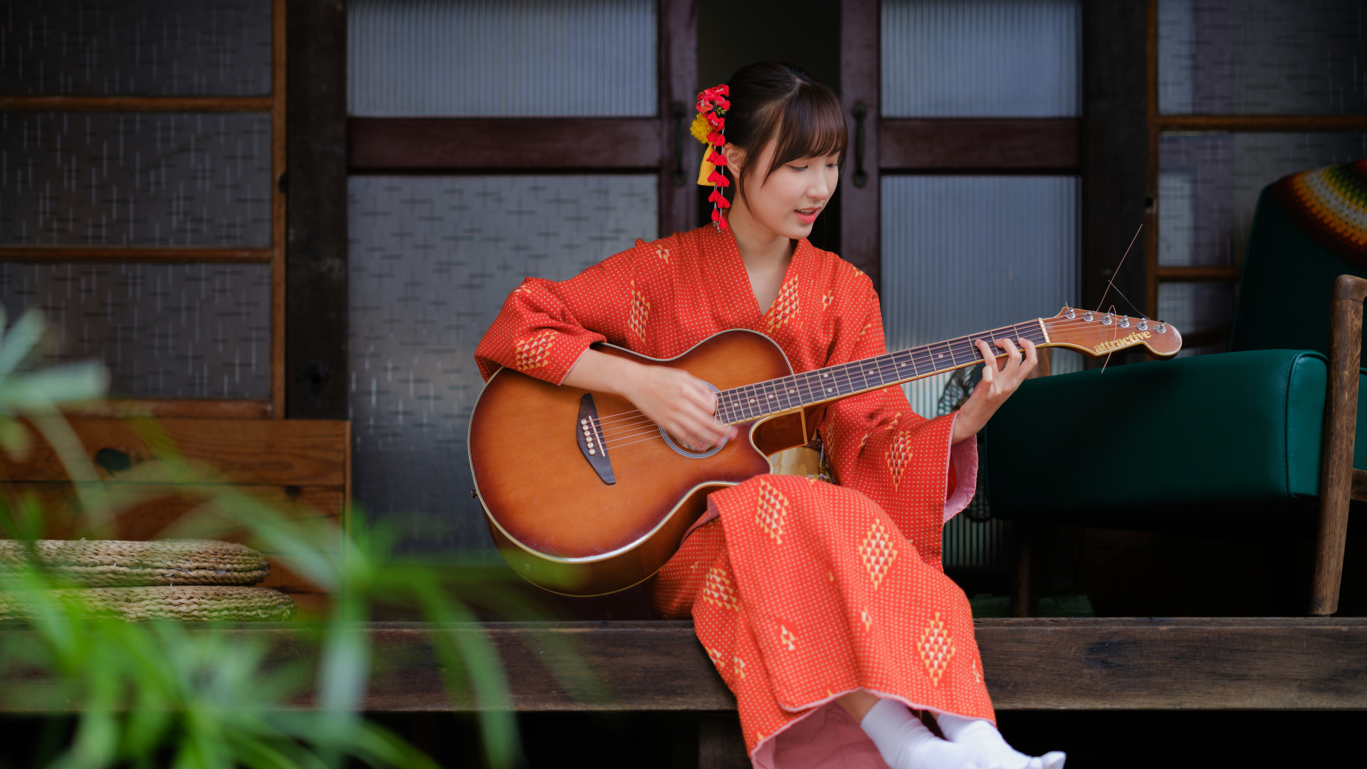 Девушка азиатка в красном кимоно с гитарой в руках